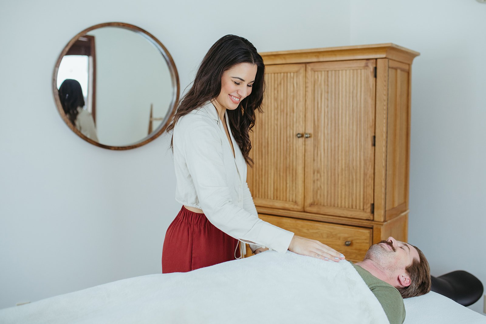 Stephanie Kamille giving Reiki to a client on a massage table
