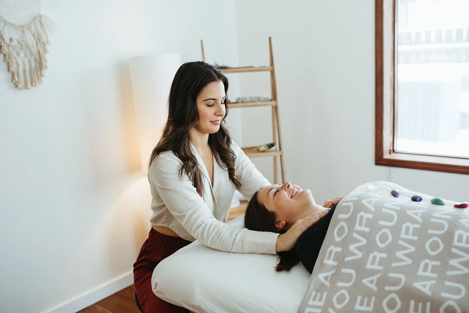 Stephanie Kamille is giving Reiki to a woman on a massage table