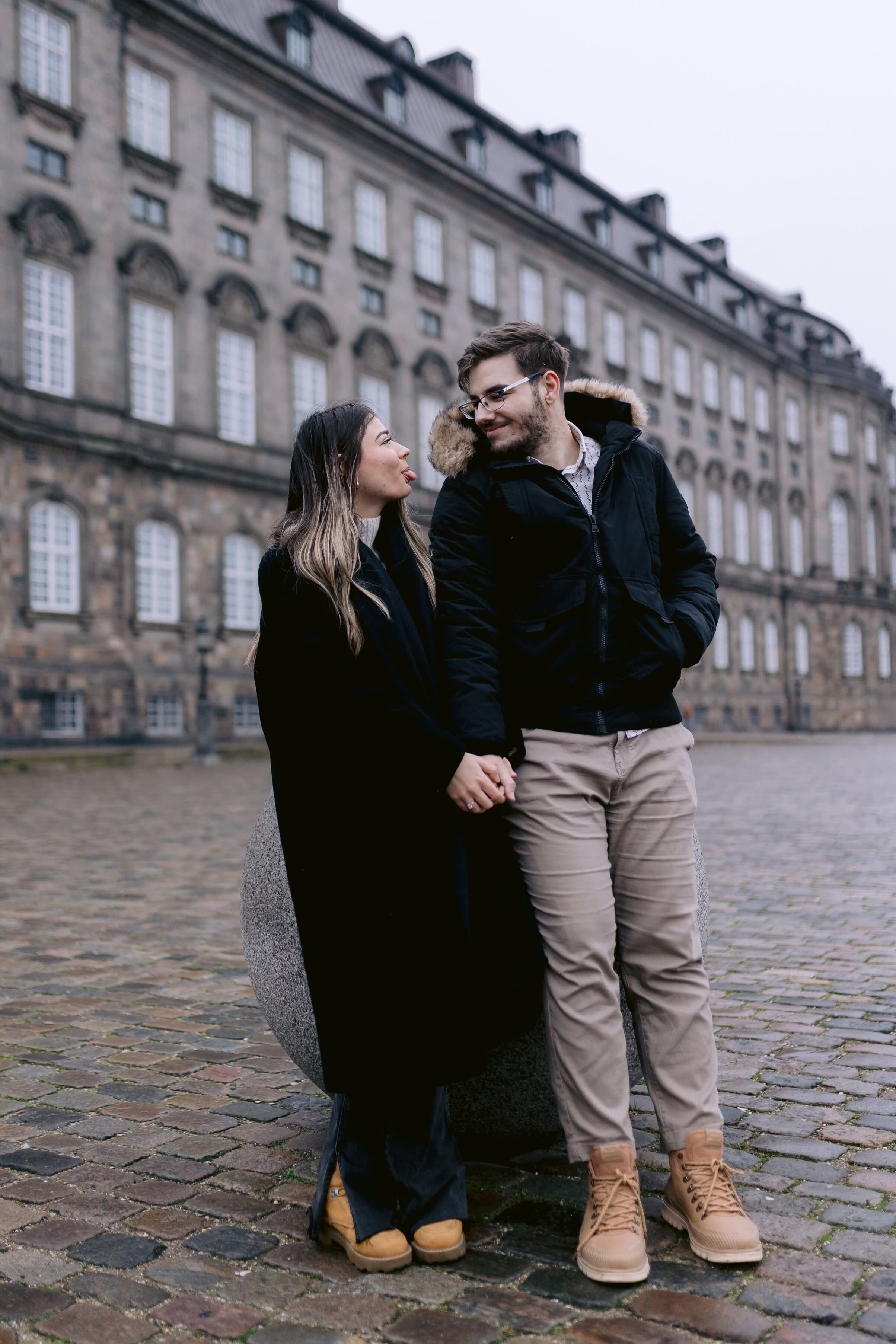 Suprise proposal photoshoot in copenhagen: the couple sticking out tongues