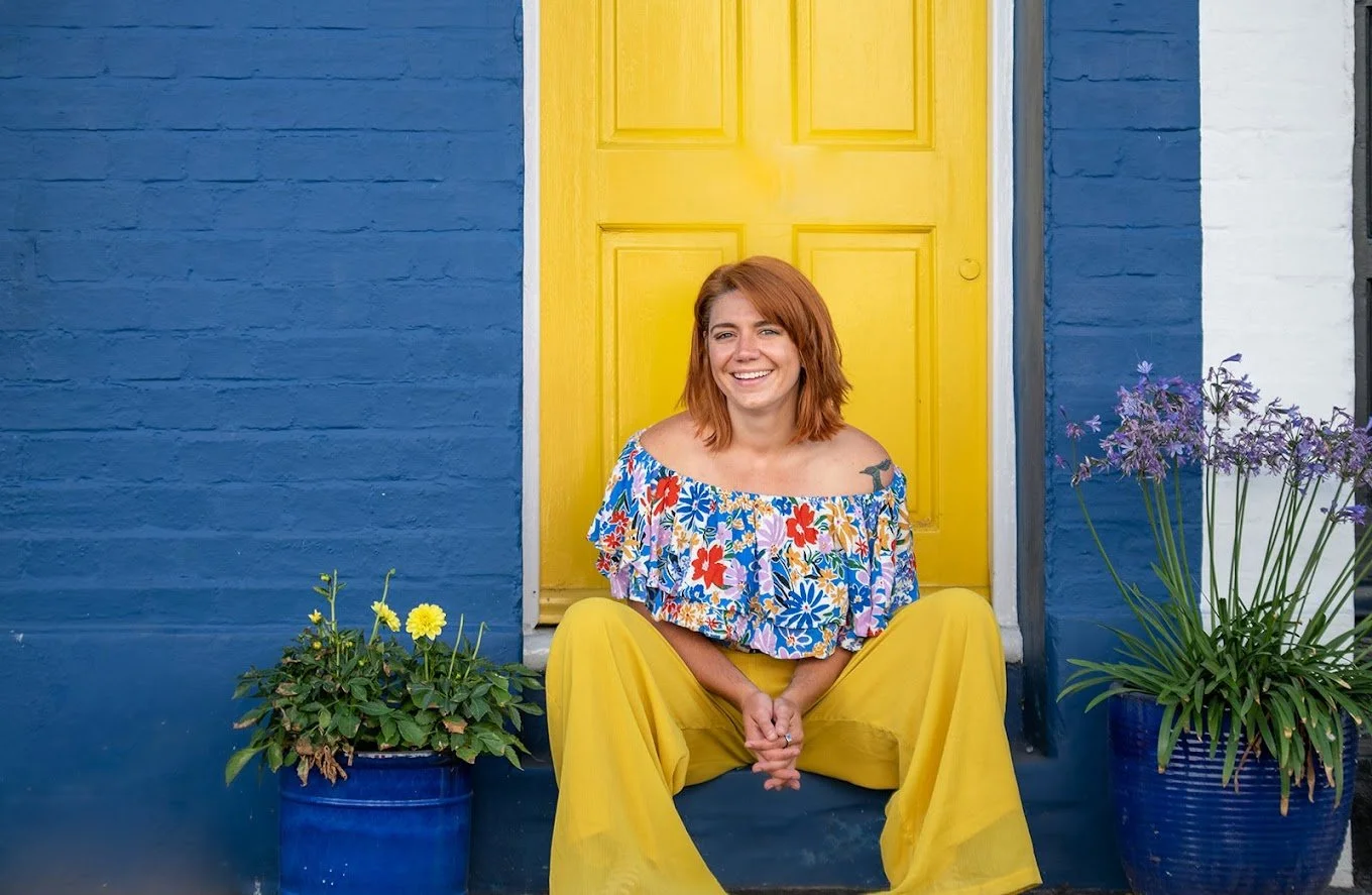 International psychotherapist sits in front of a yellow door