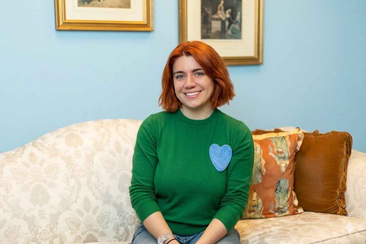 Online EMDR therapist sits on a couch in green sweater