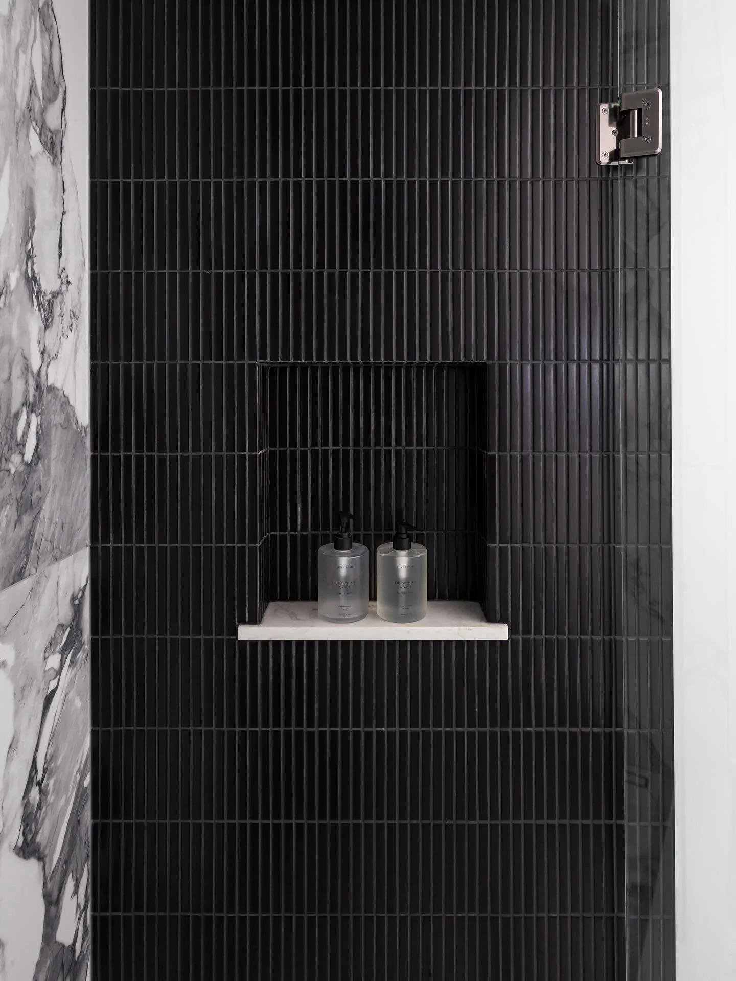 Step into this stunning guest bathroom, where functionality meets beauty. We took a tired guest bath and transformed it into a luxurious retreat that your guests may never want to leave! 

We designed multi-purpose millwork to boost storage and style