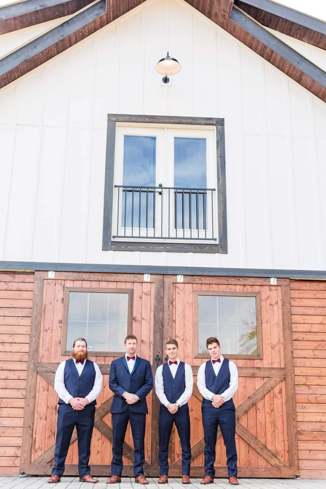 Four men in suits standing outside the barn at a Knoxville wedding venue