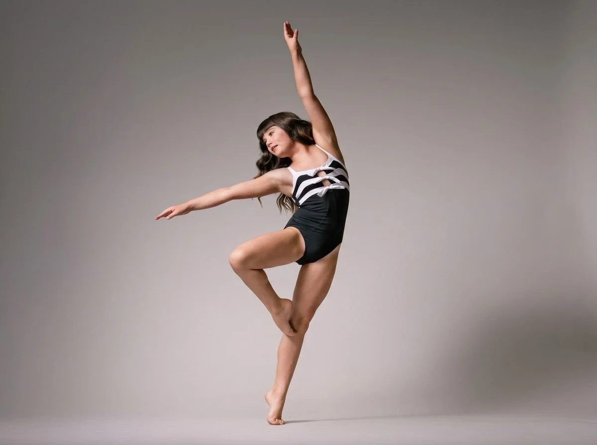 Female dancer in black and red attire on a natural color backdrop in an abstract pose.