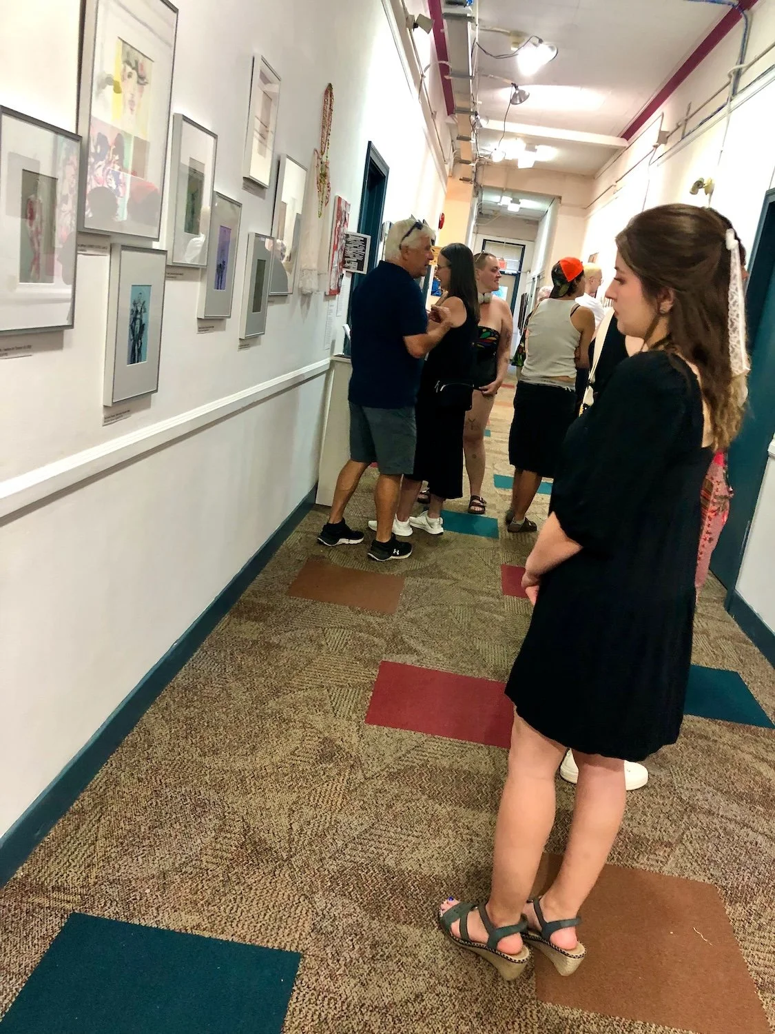 Private view visitors looking at Seb Black fashion illustrations