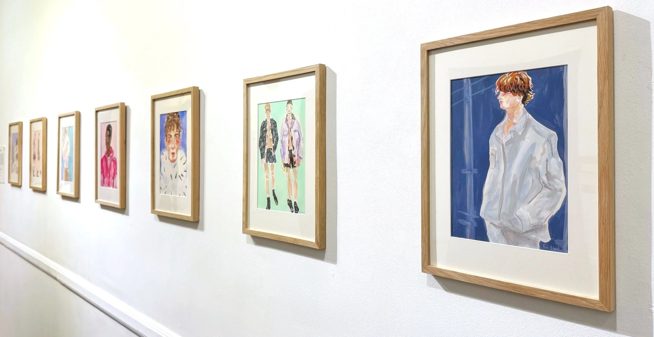 installation view of Seb Black fashion illustrations at an exhibition showing menswear