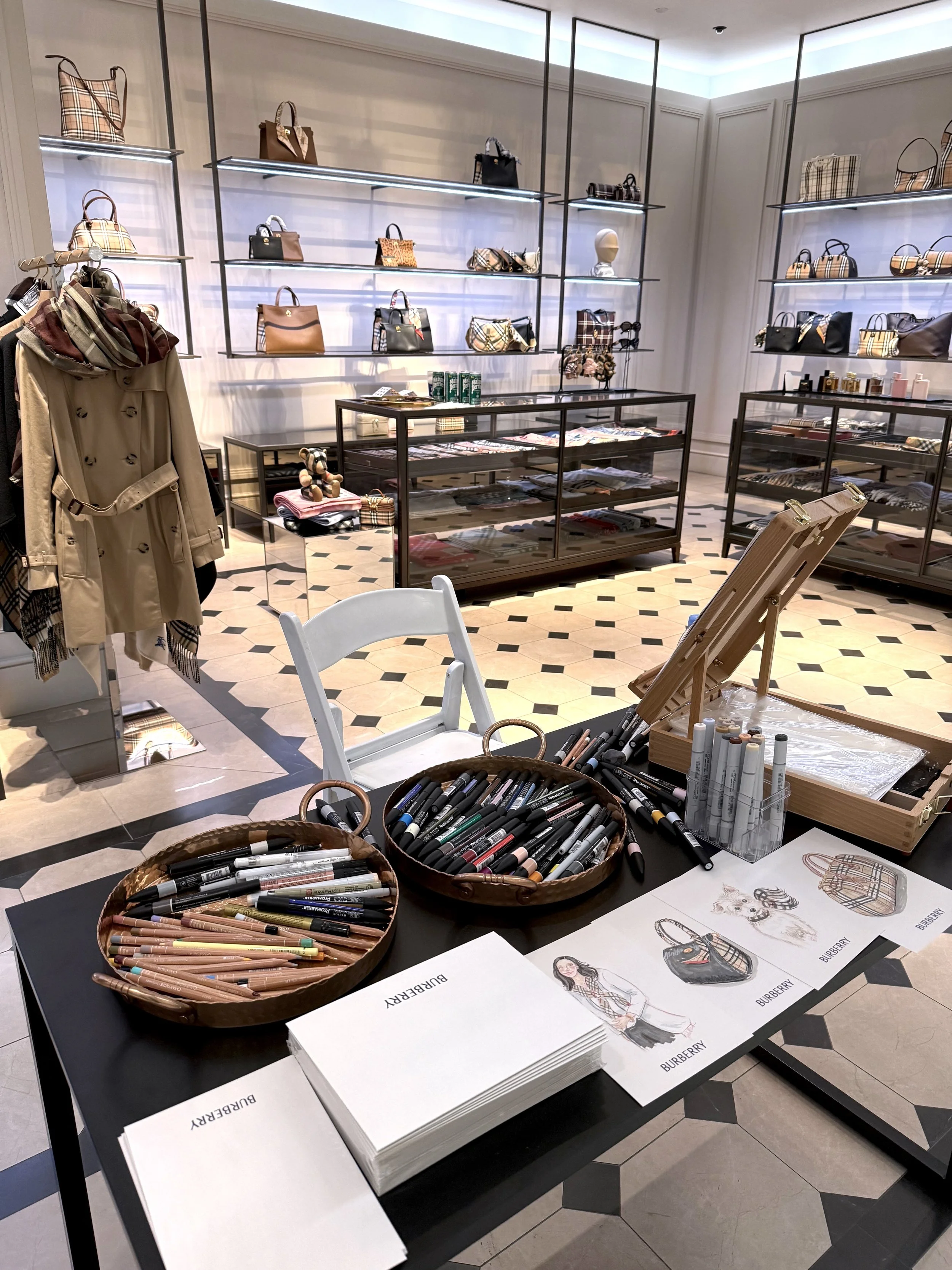 luxury fashion illustration table with live client and product  illustrations with handbags and accessories in a boutique