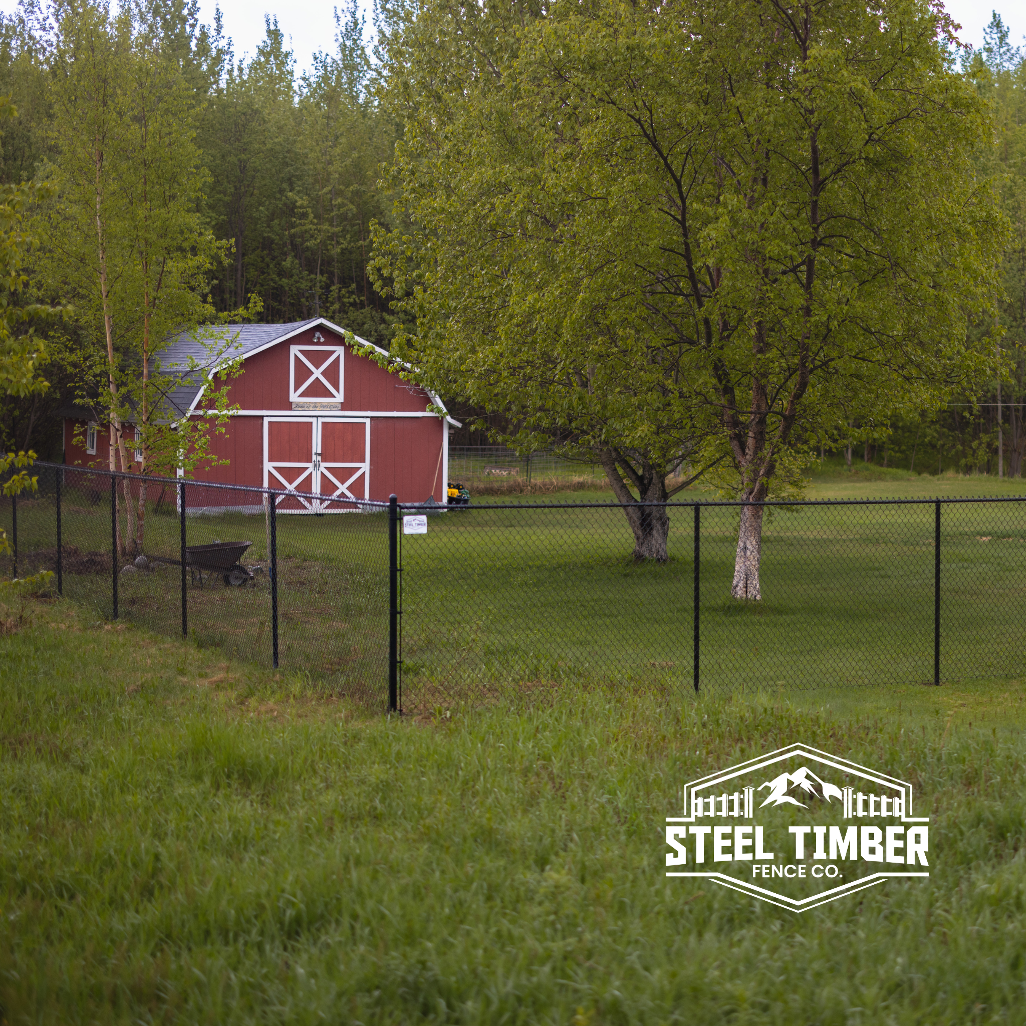 Black vinyl chain link fence by Steel Timber Fence Co.