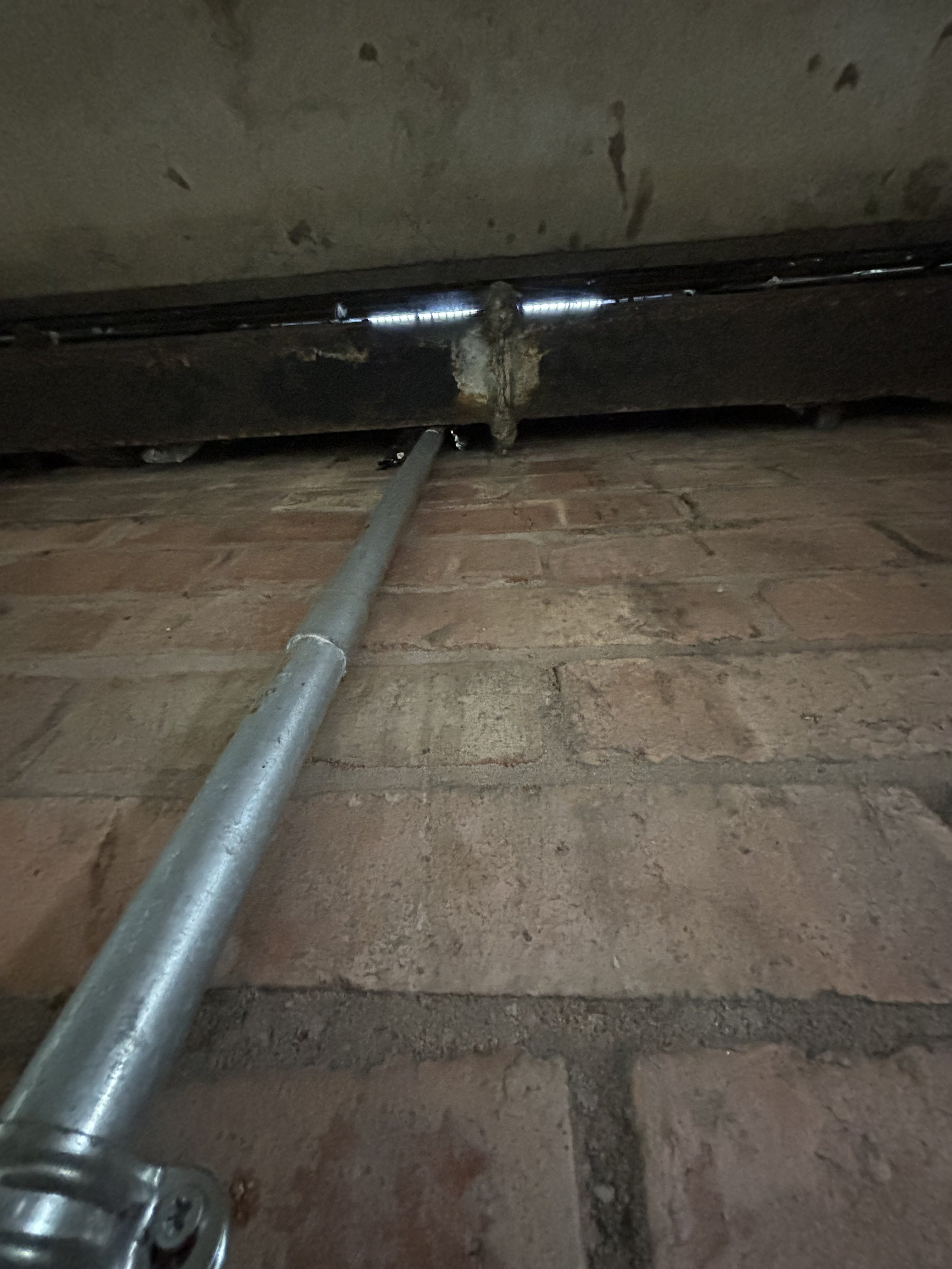 THE CONCRETE CAR PARK SHOWS A VERY TALL VERTICAL PIPE WHICH SEEMINGLY GOES FROM THE VERY TOP DOWN TO THE VERY BOTTOM. THIS IS TYPICALLY SEEN IN CAR PARKS WHICH RUN AS AN AQUAMATION FACILITY