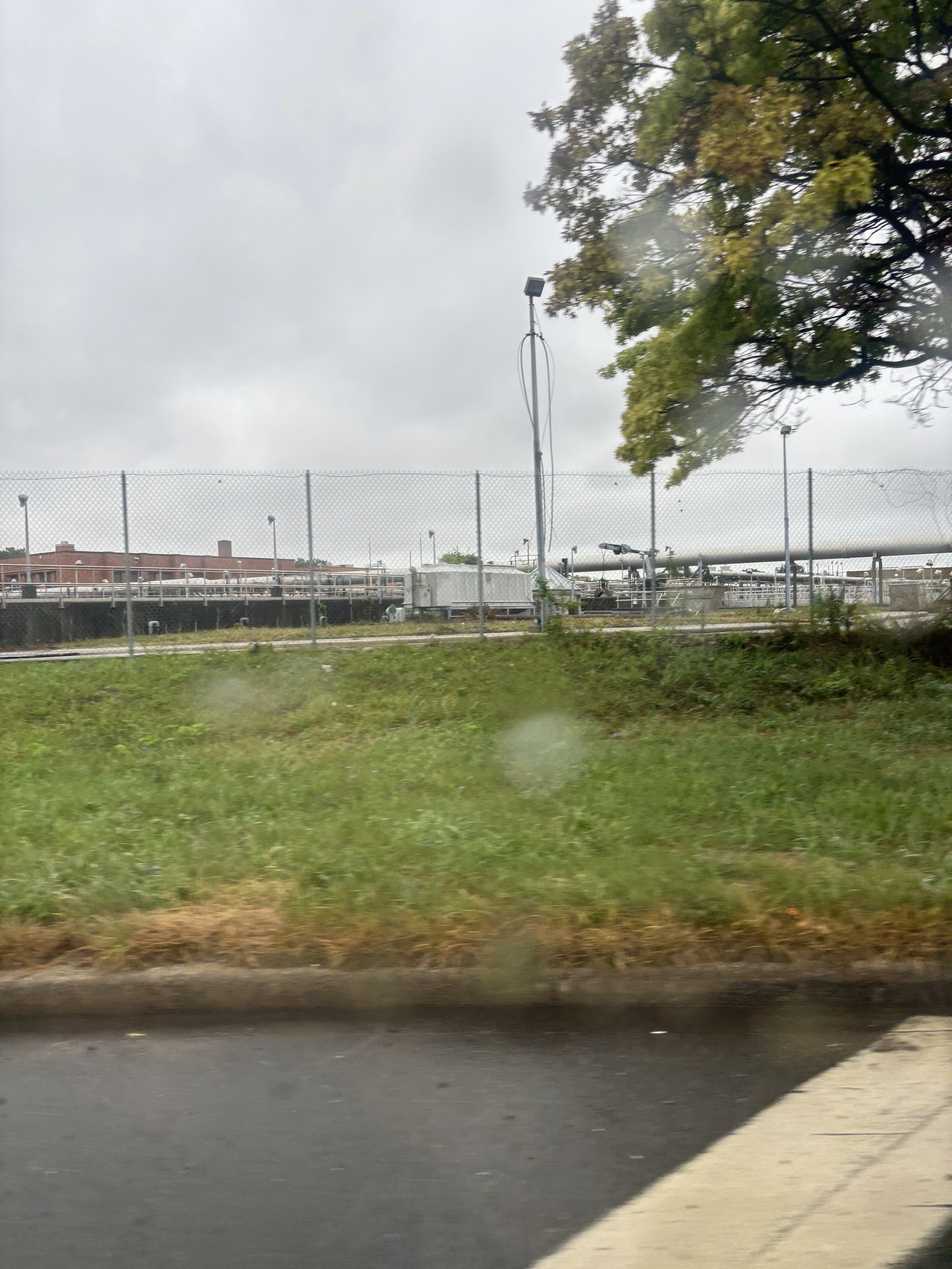 HUGE PIPES OF WHAT LOOKS LIKE AN AQUAMATION FACILITY IN THE BACKGROUND UPON ENTERING THE PERIMETER OF JFK AIRPORT
