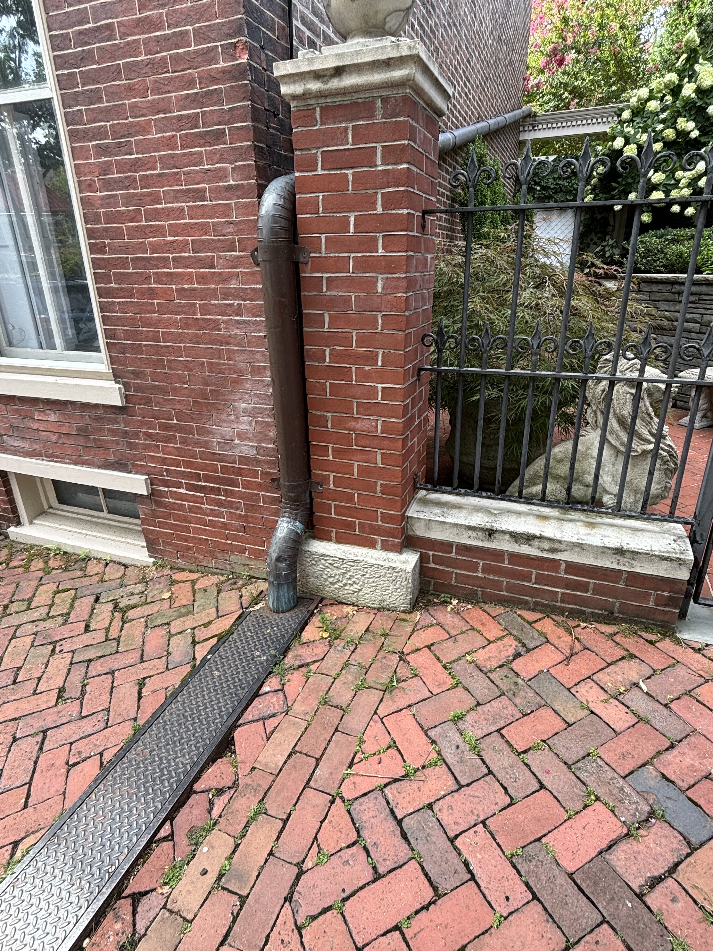 A LARGE CIRCUMFERENCE PIPE RUNNING FROM THE BACK AREA TO THE FRONT AND THEN COVERED AS IT TRAVELS ACROSS THE PAVEMENT