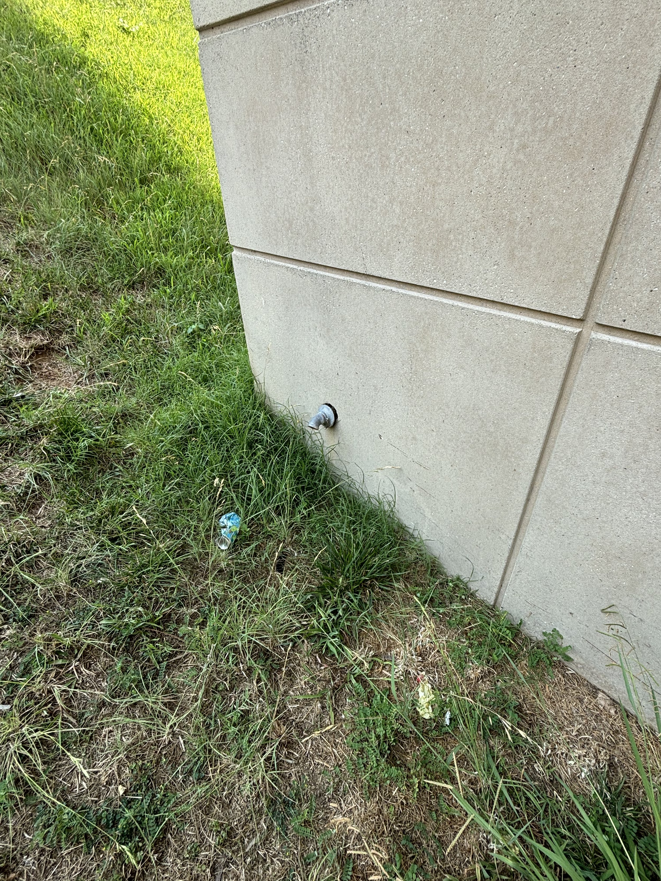 OUTSIDE A TAP IS PRESENT AND IT SEEMS LIQUID DOES EXIT SINCE THERE IS CAKED (CRACKED) MUD NEARBY