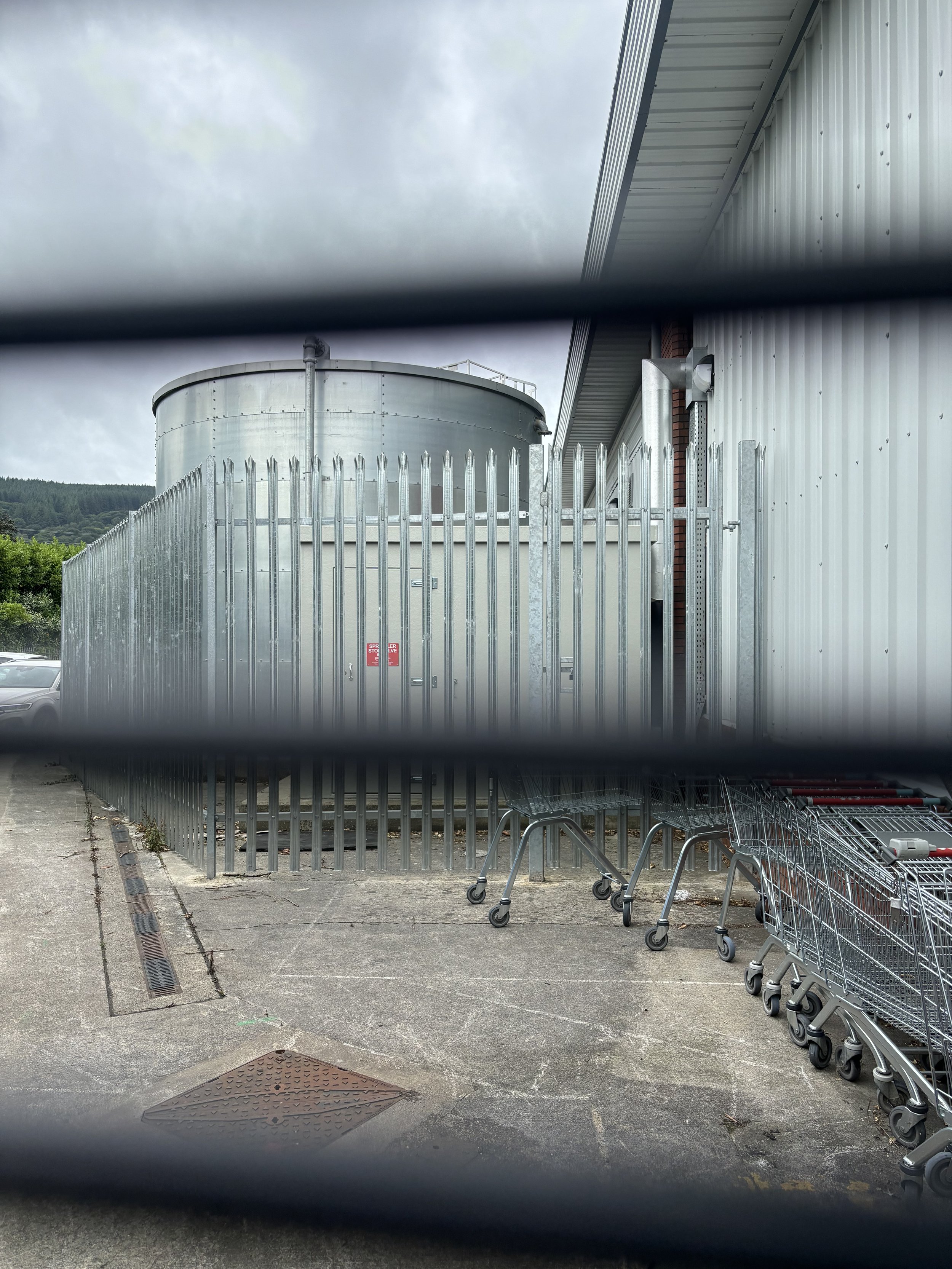 IN PENTREBACH A HUGE LIQUID CONTAINER WITH A CHIMNEY AND OUTLET FUMES IS TO THE LEFT OF THE OLD 'PC WORLD' PREMISES. THE SMELL OF BURNING IS STRONG AND THIS WOULD BE FROM THE INCINERATOR