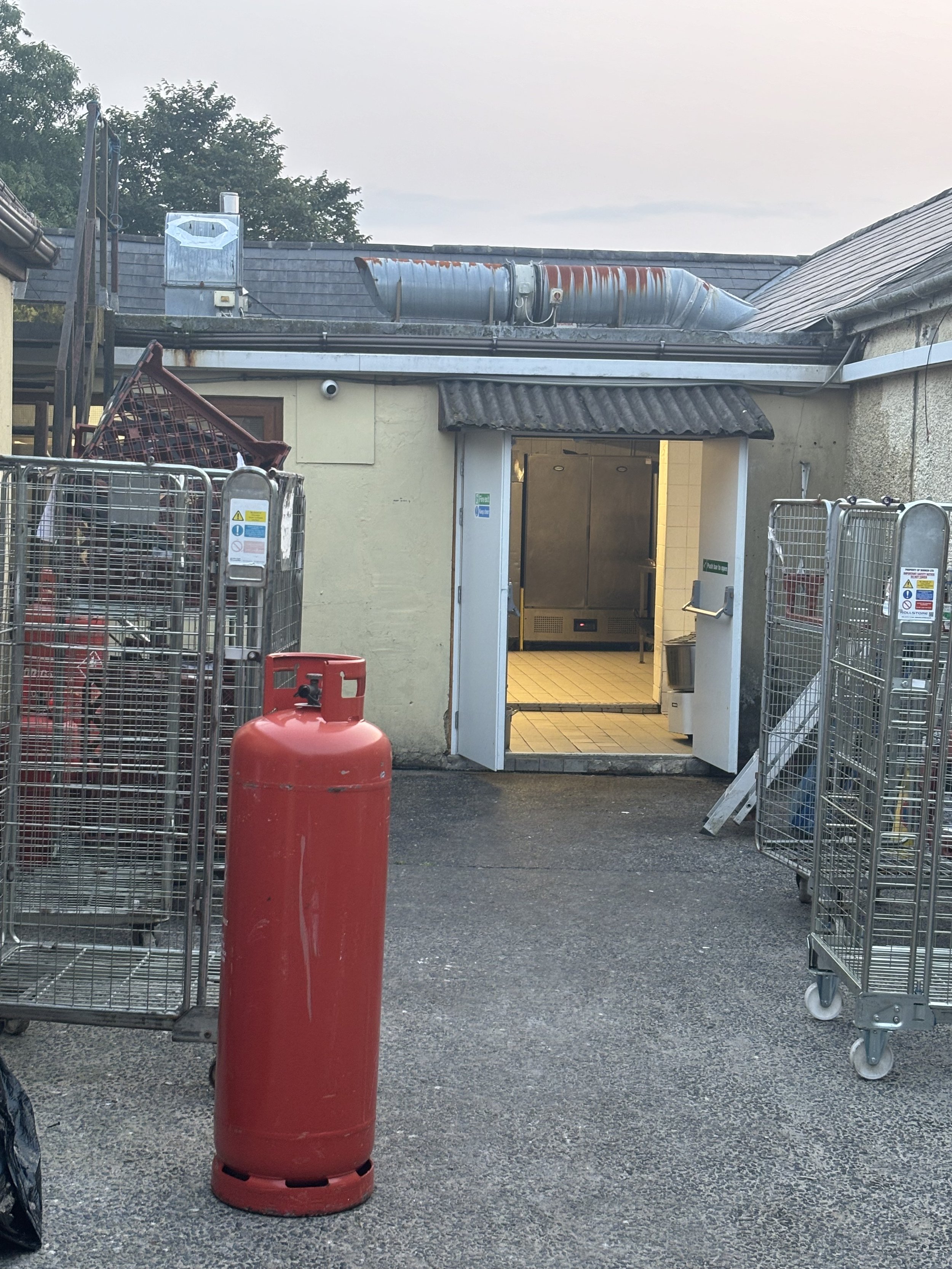THE ENTRANCE TO THE KITCHEN AREA SHOWS THE CHIMNEY AGAIN AND OTHER SMALLER CHIMNEY TO THE LEFT ON THE ROOF. A GAS CANISTER IS VISIBLE (RED) AND THIS COULD ALSO BE A SUBSTITUE FOR SULPHUR HYDROXIDE AS PART OF THE AQUAMATION PROCESS. ONCE AGAIN AS OTHE