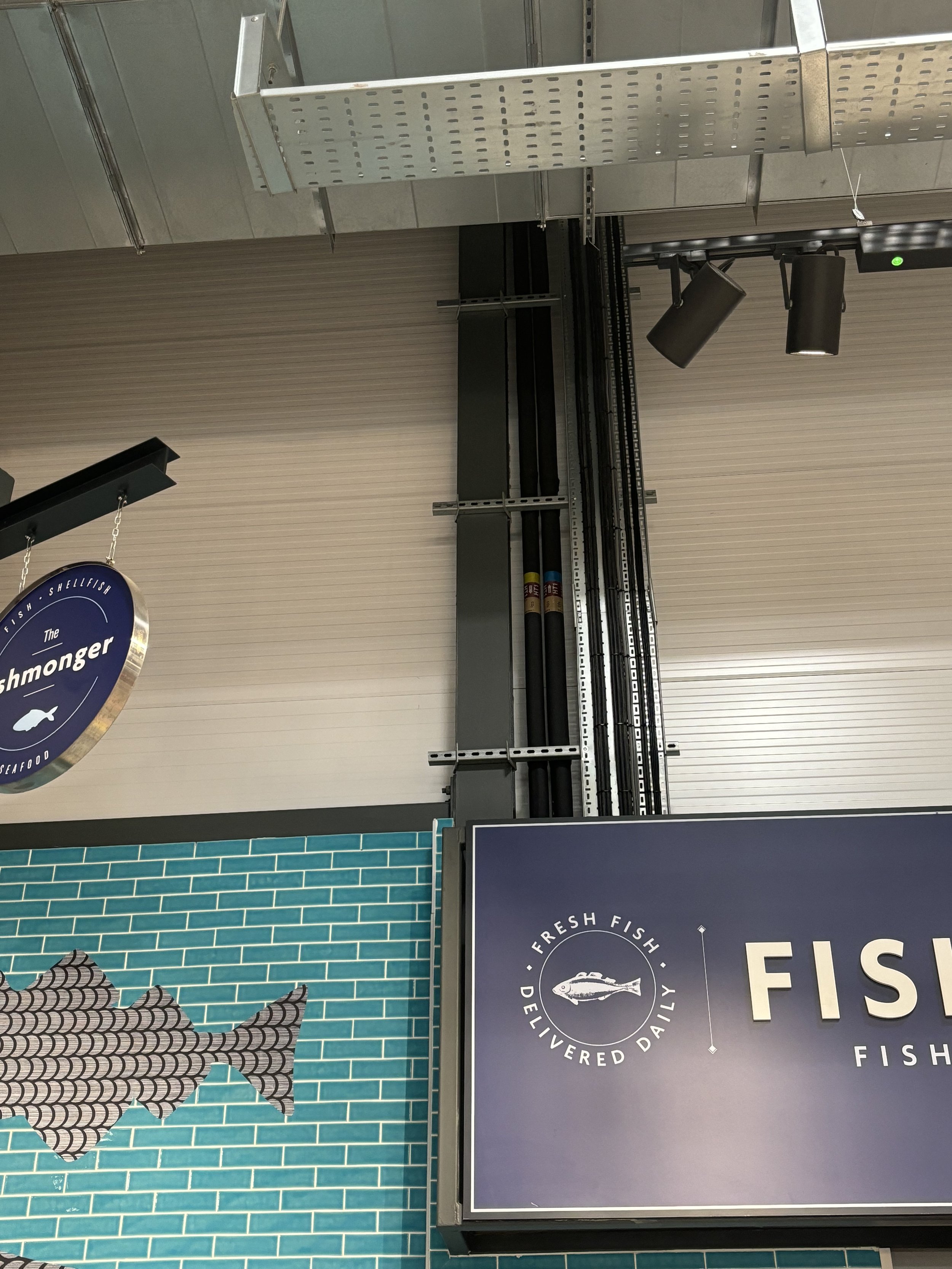 A HUGE CABLING AND PIPING SYSTEM RUNNING VERTICALLY AND HIDDEN JUST BY THE FISH MARKET