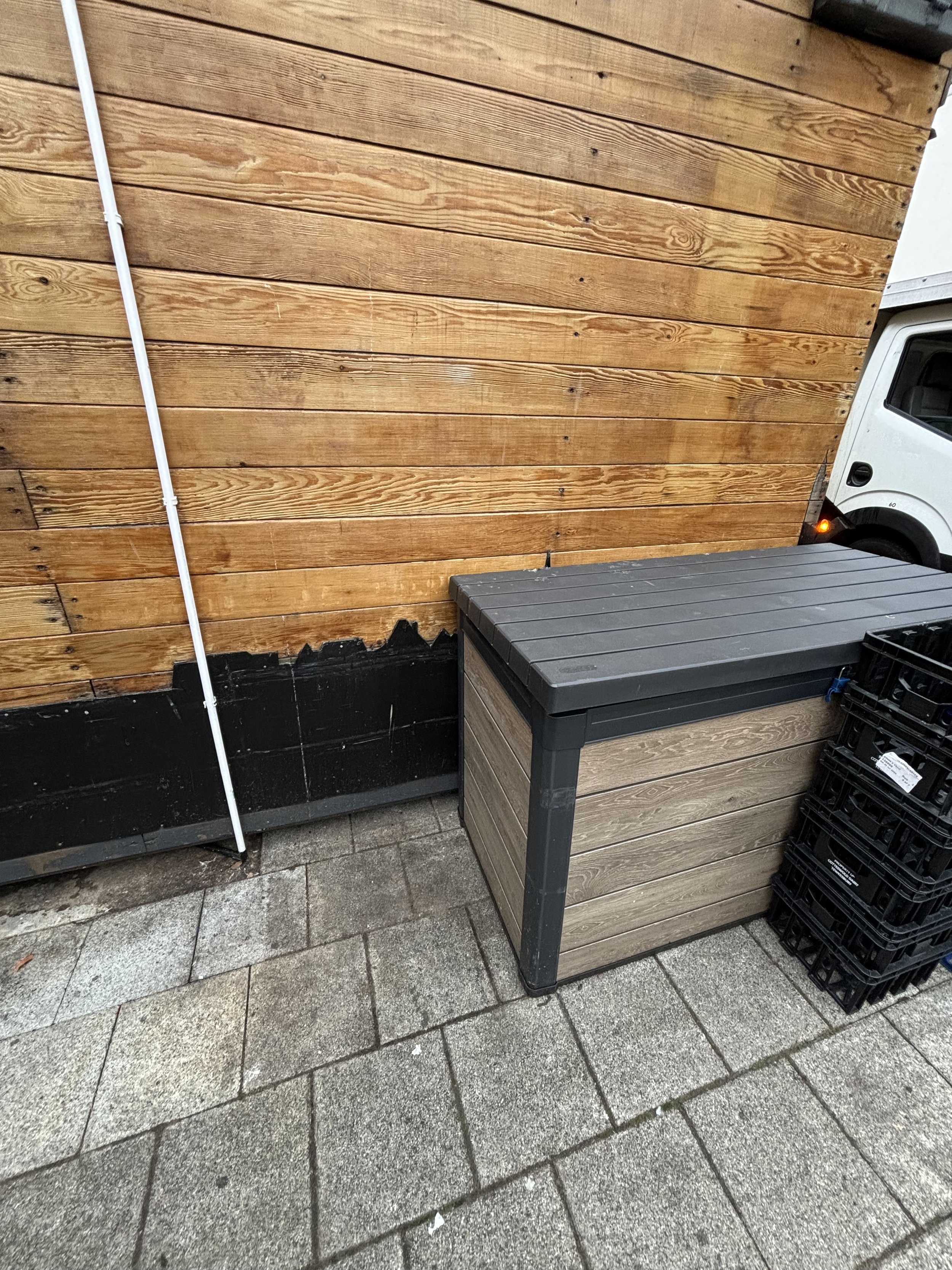 A WOTE DOWNARD PIPE GOES FROM TOP TO BOTTOM AND A CONTAINER WHICH HAS UNKNOWN CONTENT INSIDE