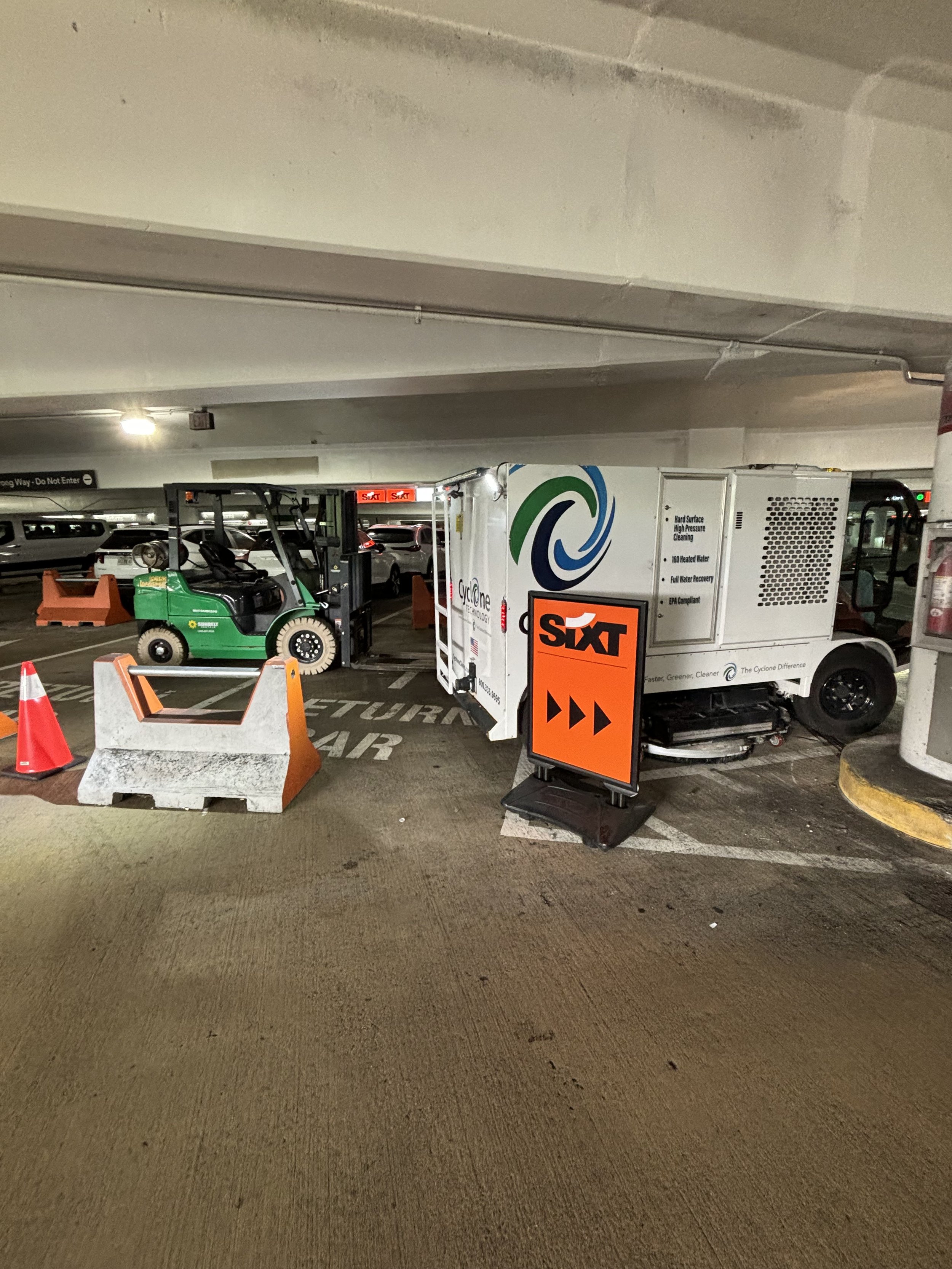 THE FAR SIDE OF THE CAR RENTAL AREA HAS A LOT OF CHAOS AND FLASHING LIGHTS. IT CREATES EMOTIONS CAUTION, HIGH-ALERT AND WORRY ABOUT THE SITUATION