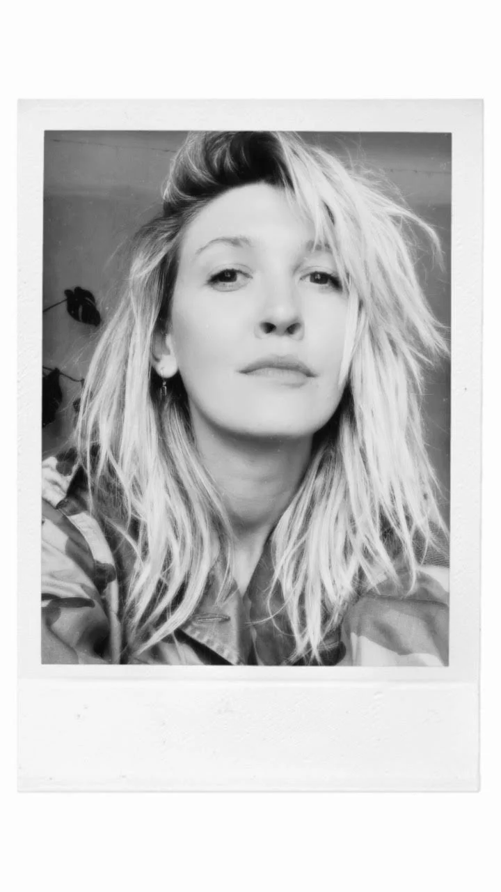 Black-and-white Polaroid picture of Alice with shoulder-length blonde hair..