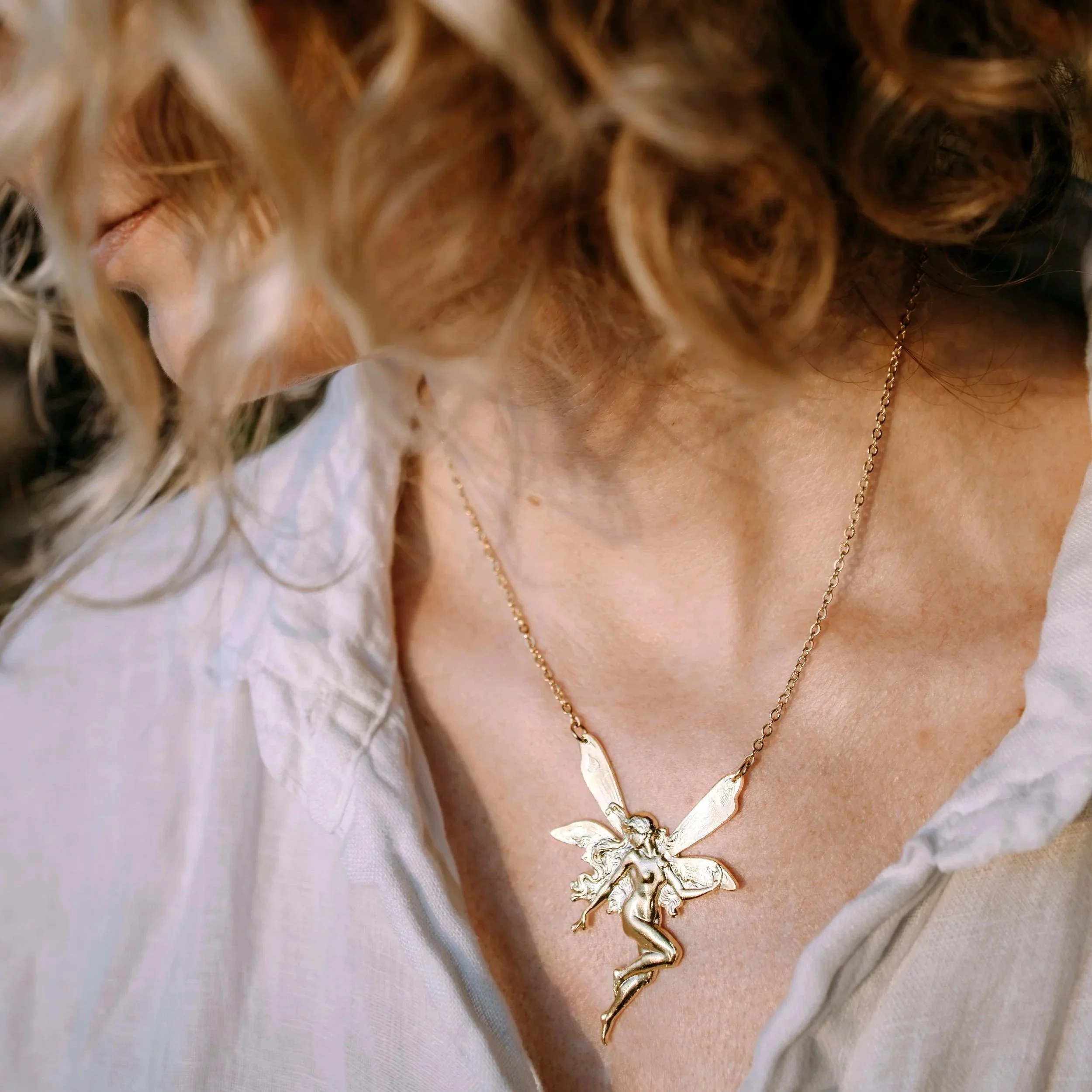 Collier fée doré porté sur le décolleté