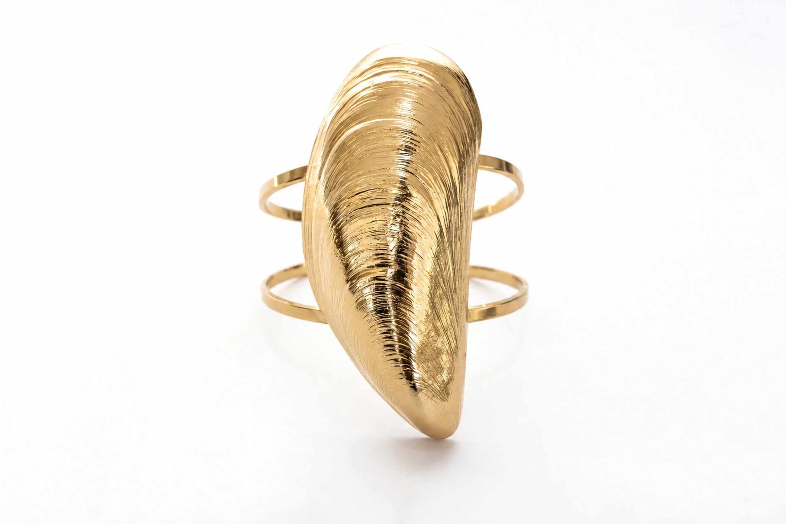 Close-up of the " cuff bracelet " mold, showing the pattern and gold finish in detail