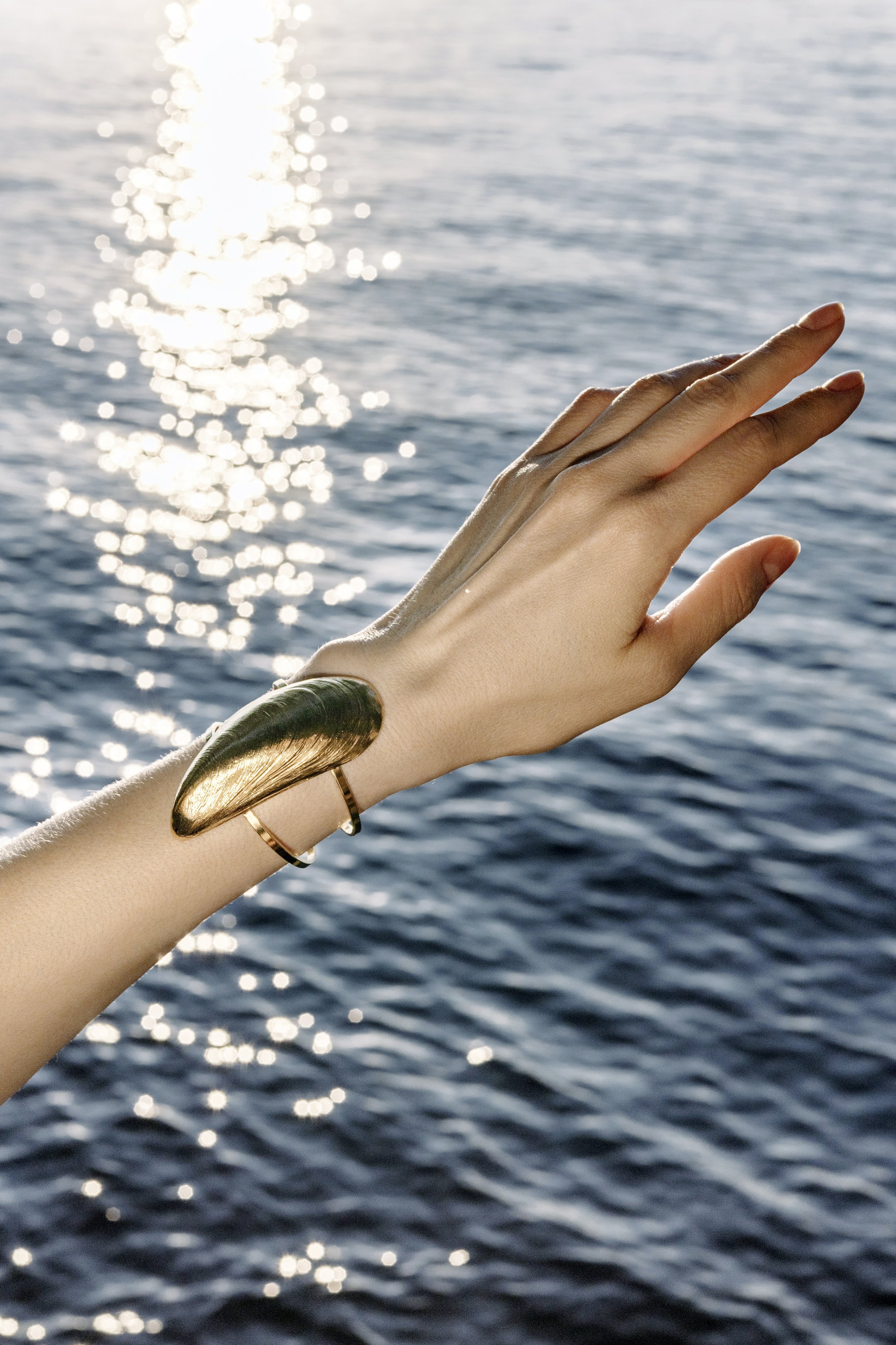 Bracelet manchette moule doré porté au poignet