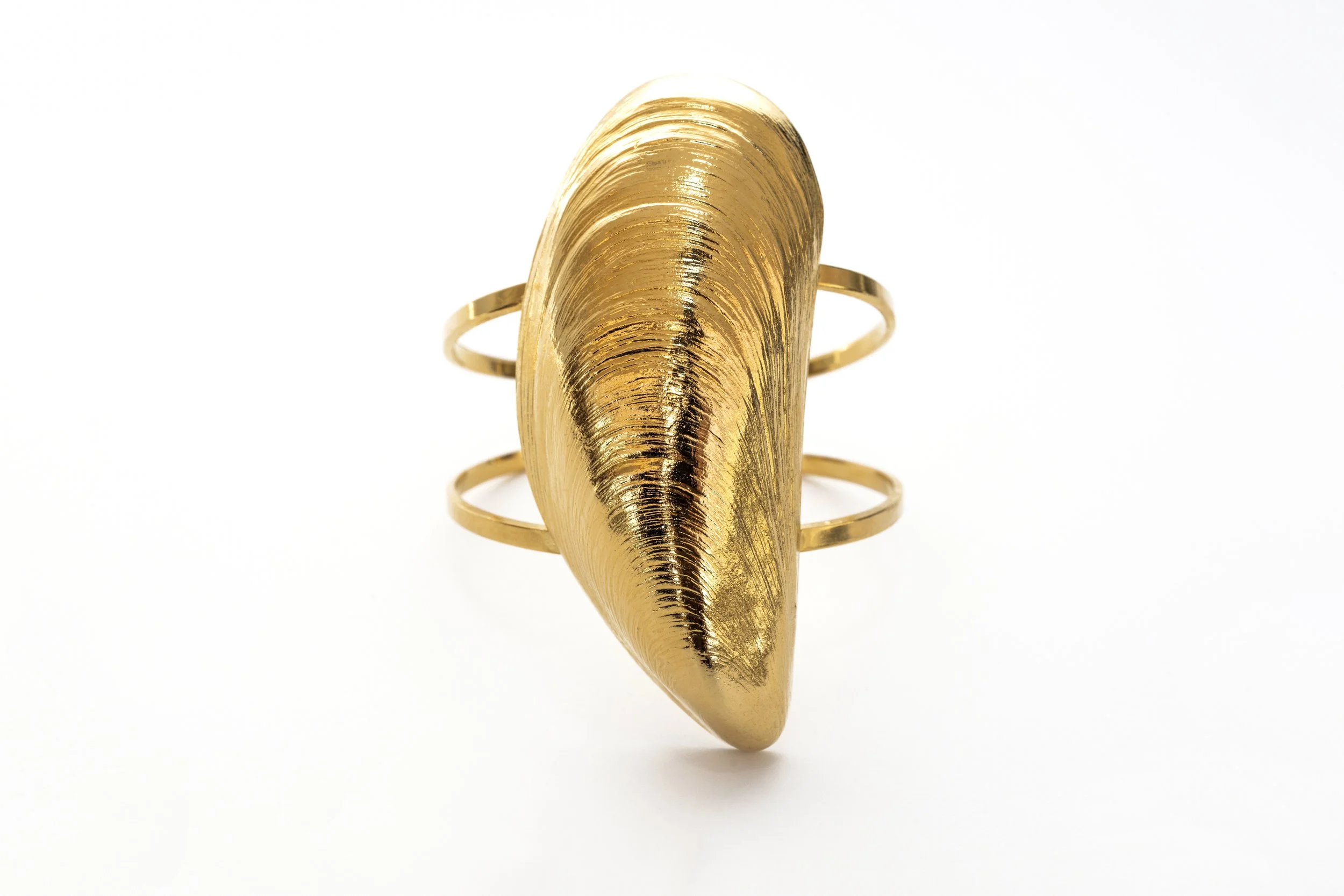 Gros plan sur le bracelet manchette moule, détail du motif et de la finition dorée