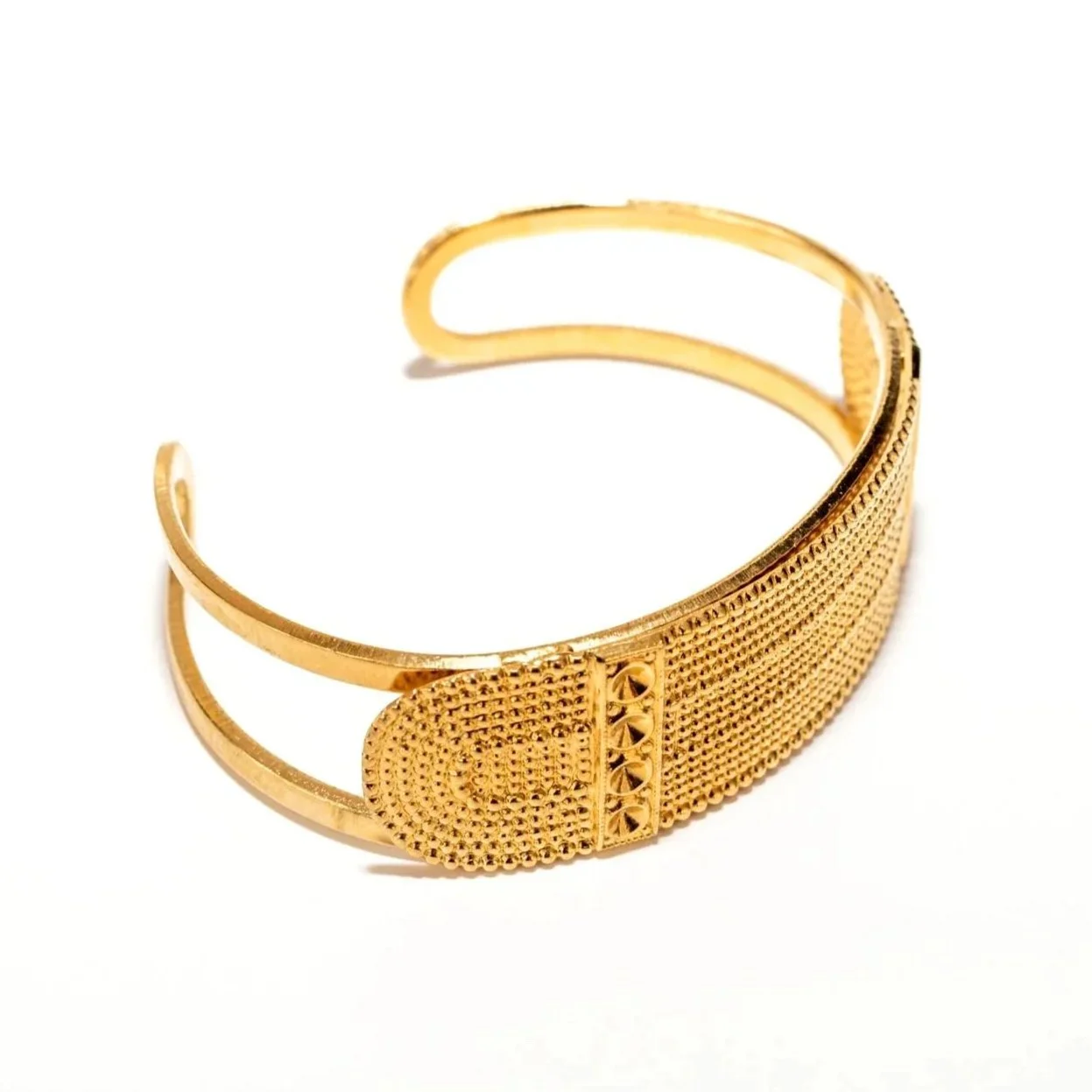 Gros plan sur le bracelet manchette Bellanda, détail du motif et de la finition dorée