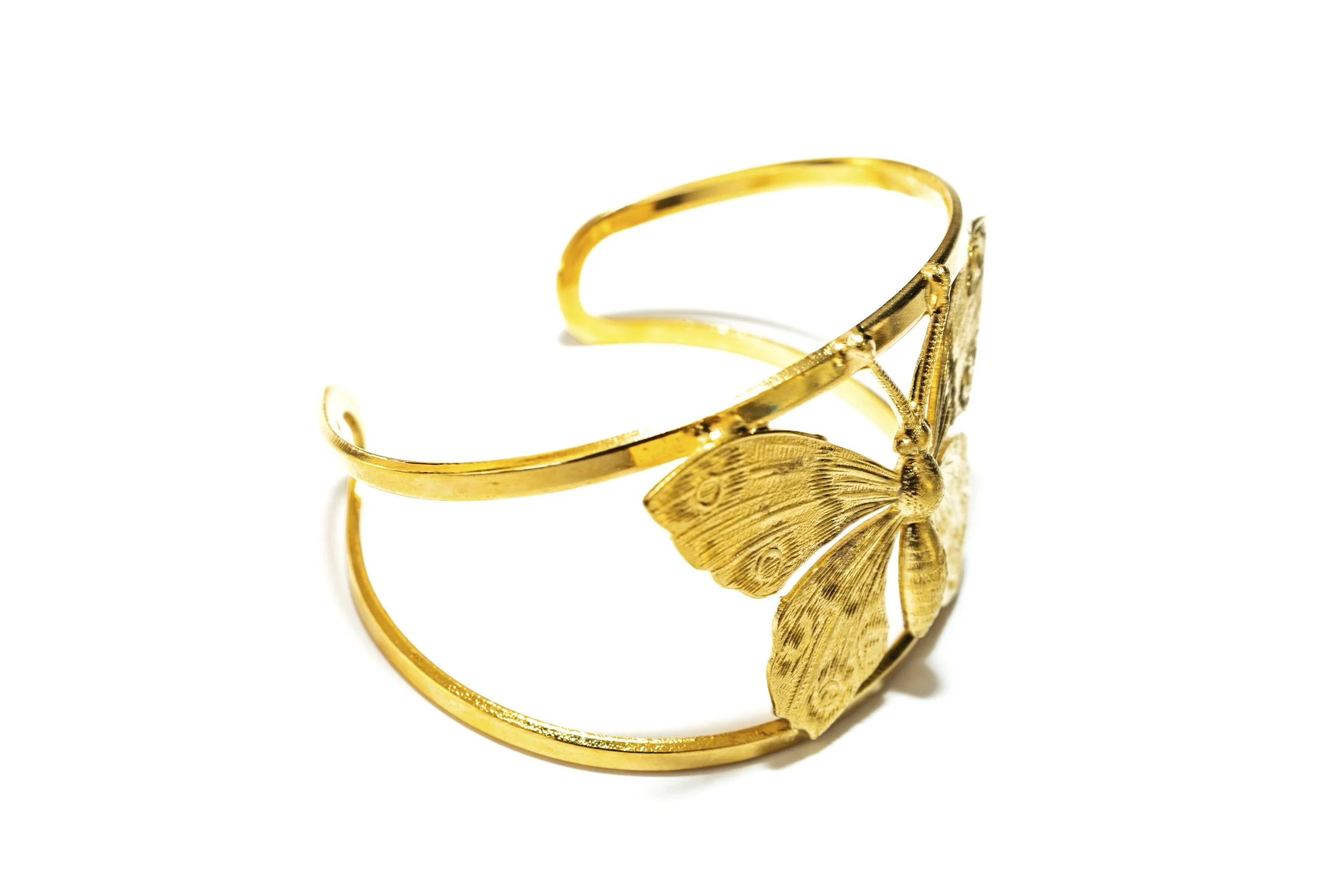 Gros plan sur le bracelet manchette papillon Machaon, détail du motif et de la finition dorée
