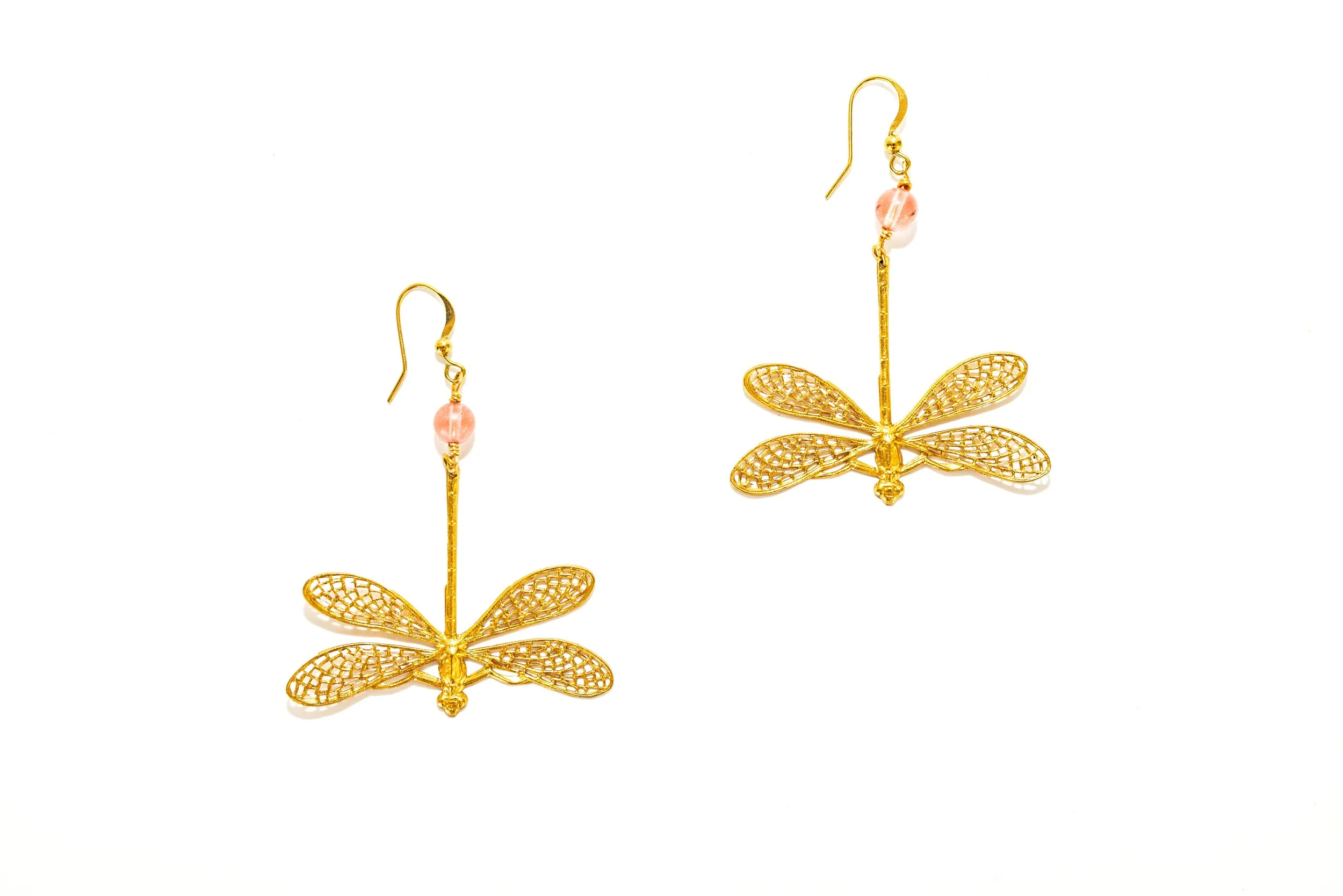 Gros plan sur les boucles d'oreilles libellules quartz rose, détail du motif et de la finition dorée