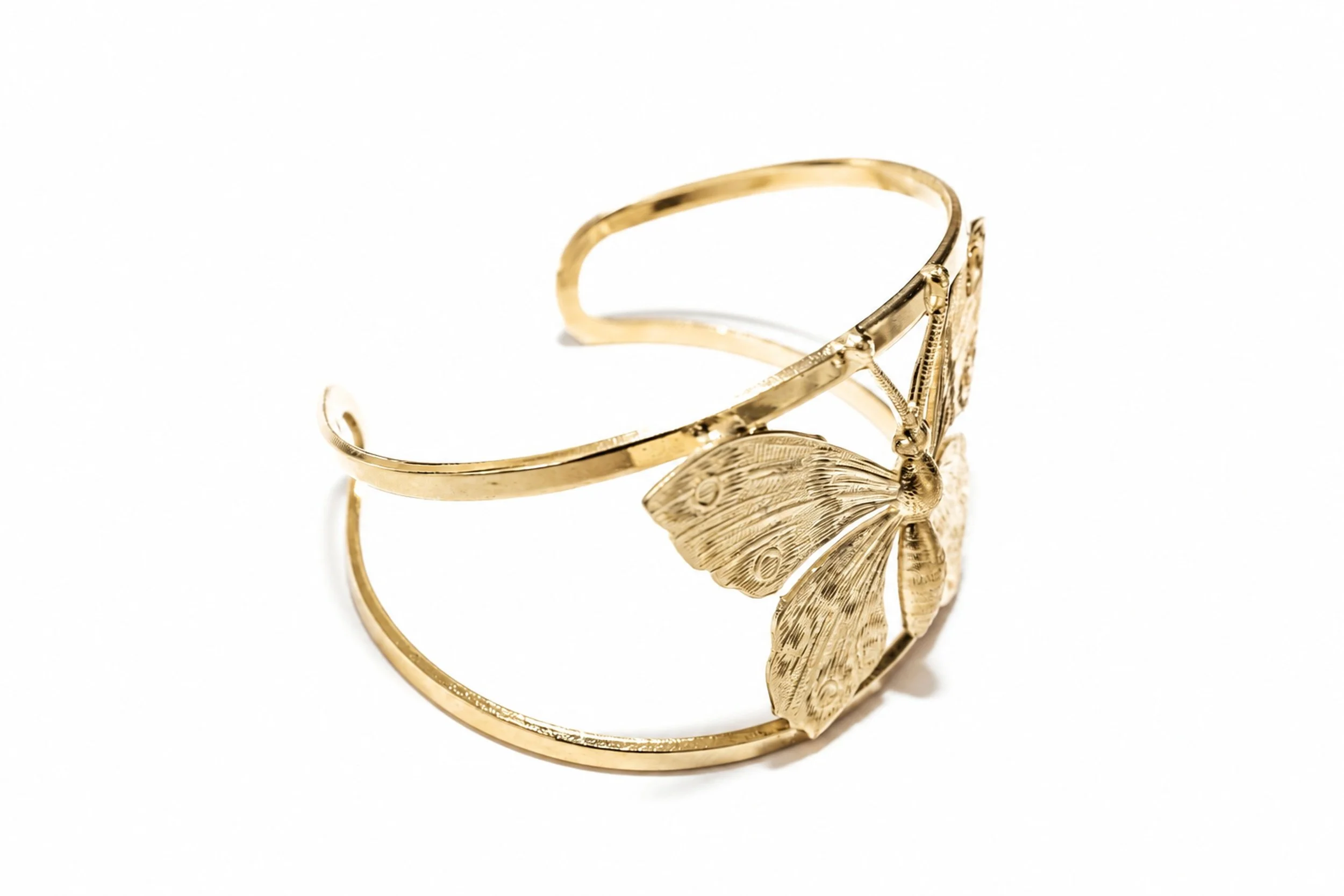 Close-up of the Machaon butterfly- cuff bracelet , showing details of the pattern and gold finish