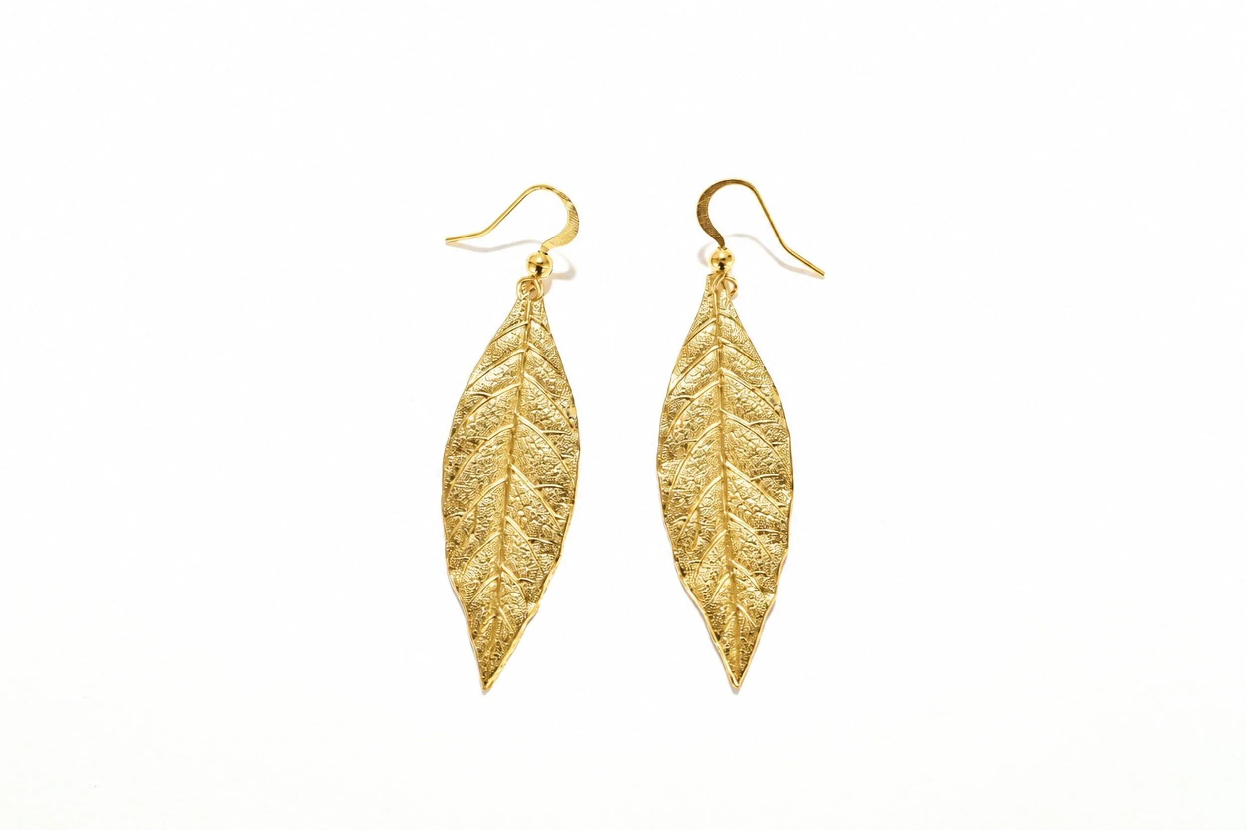 Close-up of the bay leaf earrings, showing the design and gold finish