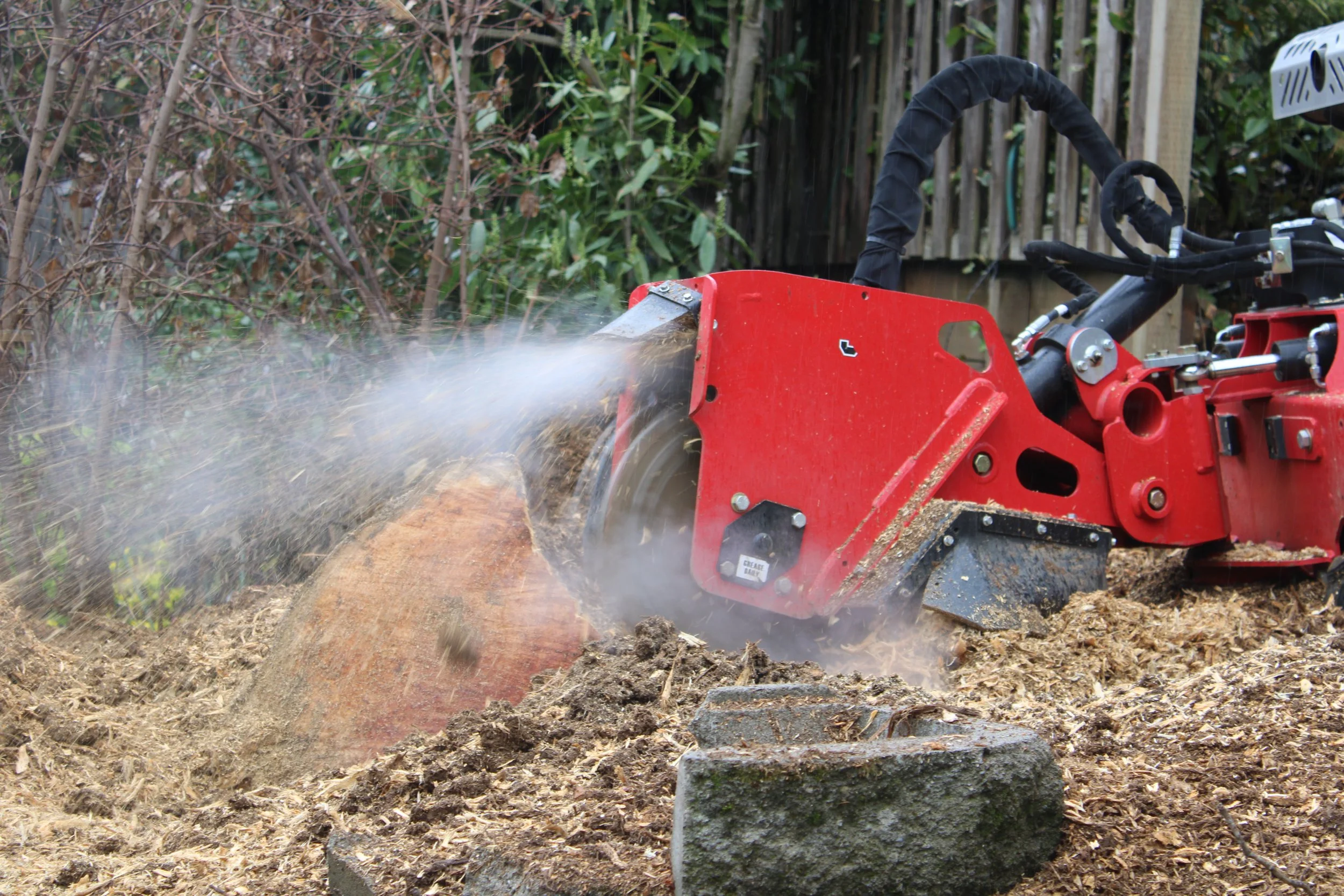Professional stump grinding service removing a tree stump as part of a completed landscaping project by Prime Landscape Services