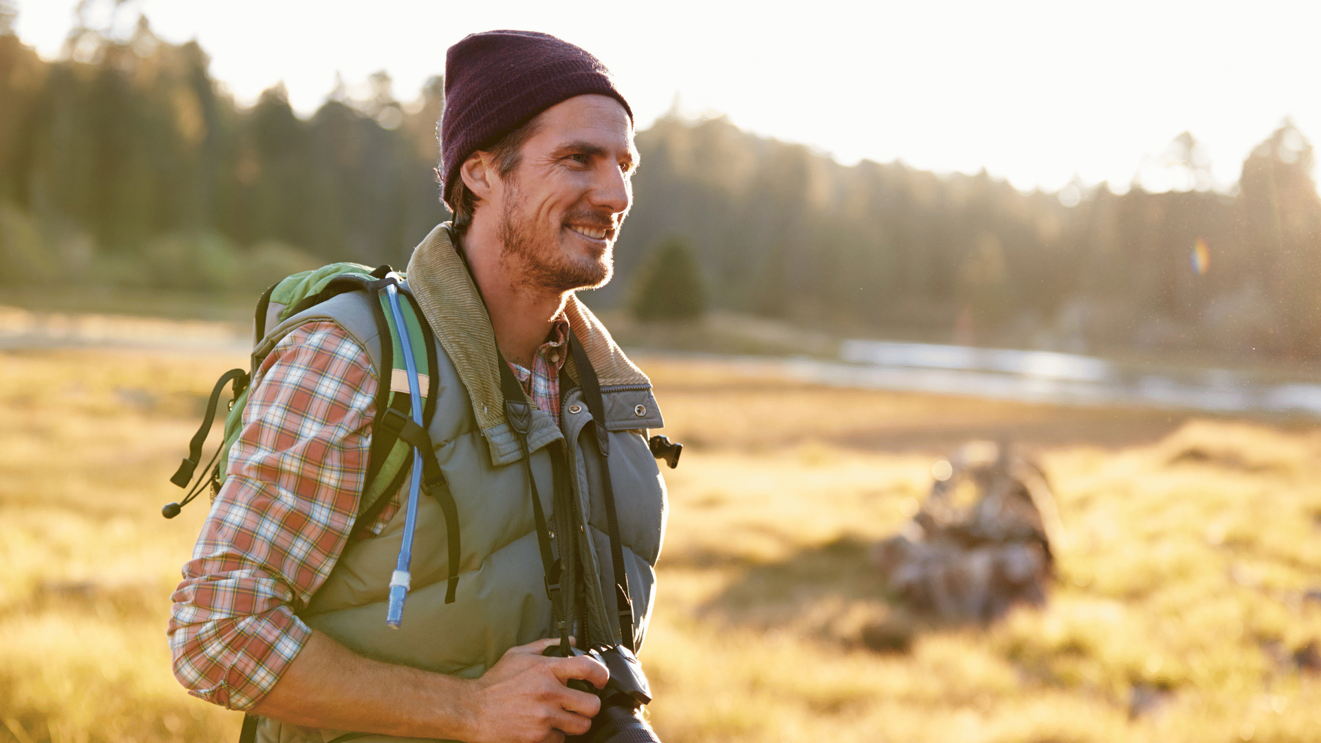 A middle ages man walking in nature with his camera in hand