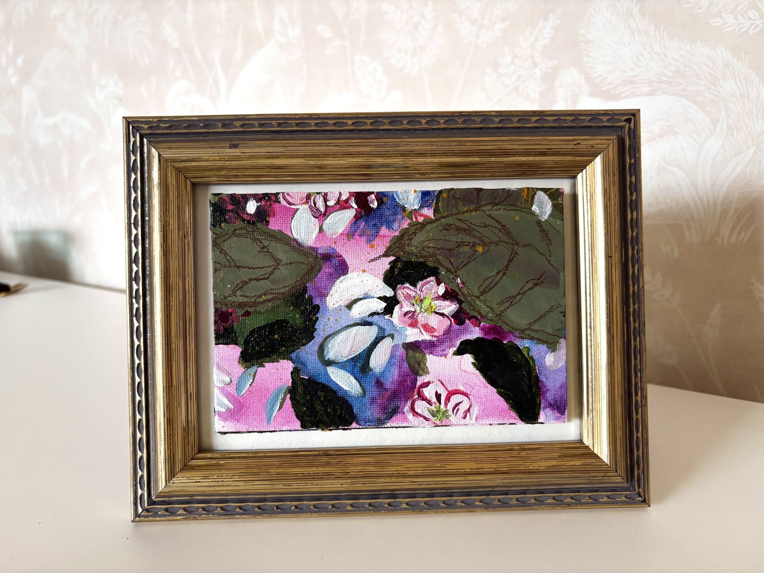 Framed painting of pink and white flowers with green leaves and water, in a modern impressionist style.