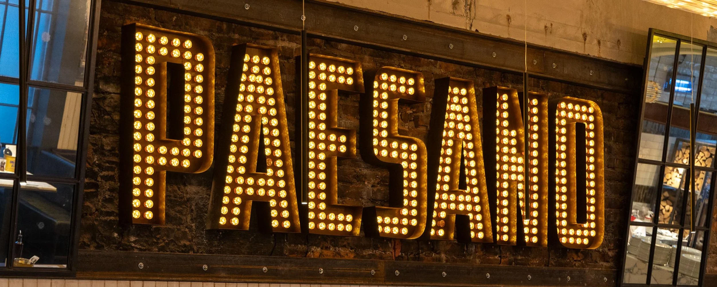large metal letters with illuminated bulbs inside mounted direct to wall