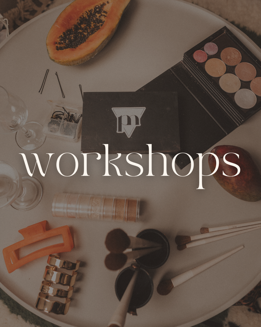 Image showing parts of a table with papaya, makeup palette, glasses, hair accessories, and makeup brushes, with the word 'workshops' overlayed.