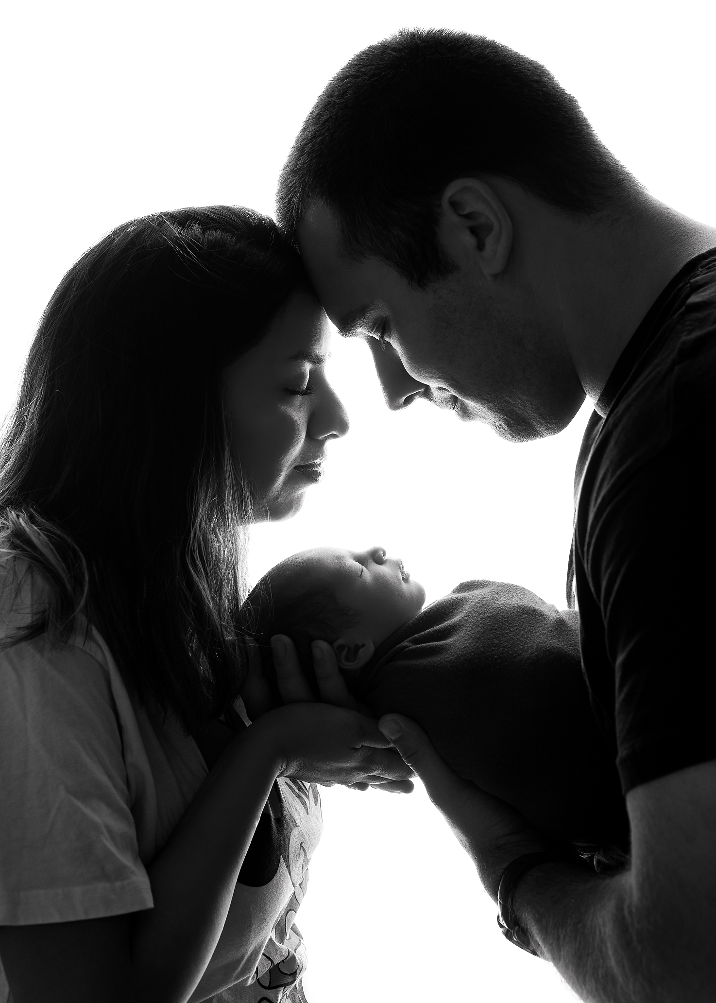 newborn boy in parents hands in black and white