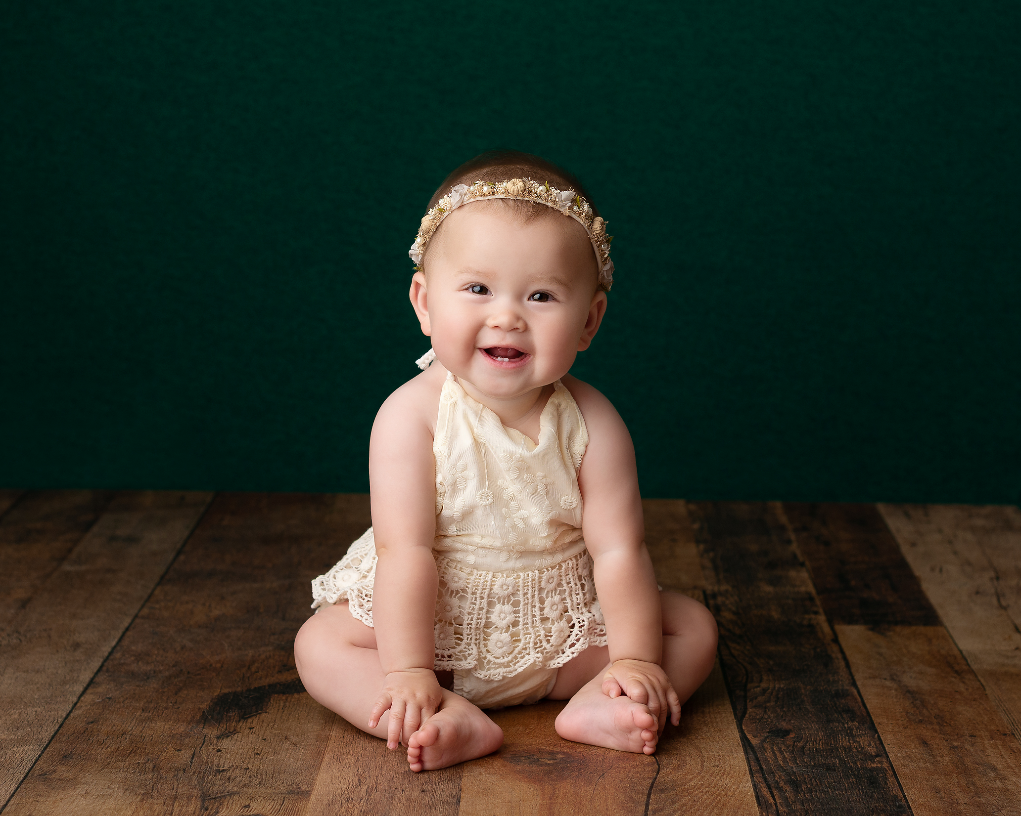 baby-girl-cream-romper-green-backdrop-Kingston-family-photographer.png