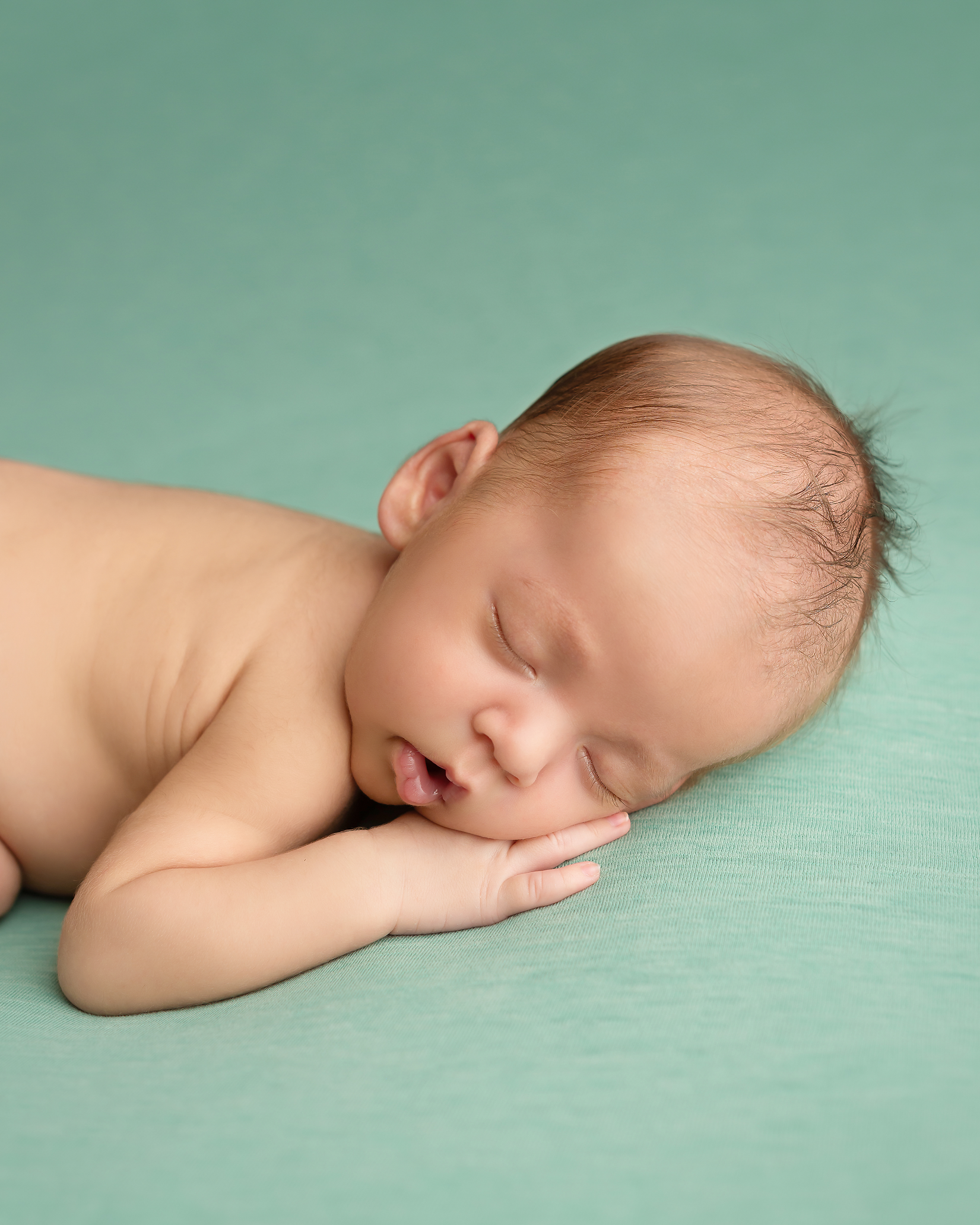 baby boy sleeping on green blanket