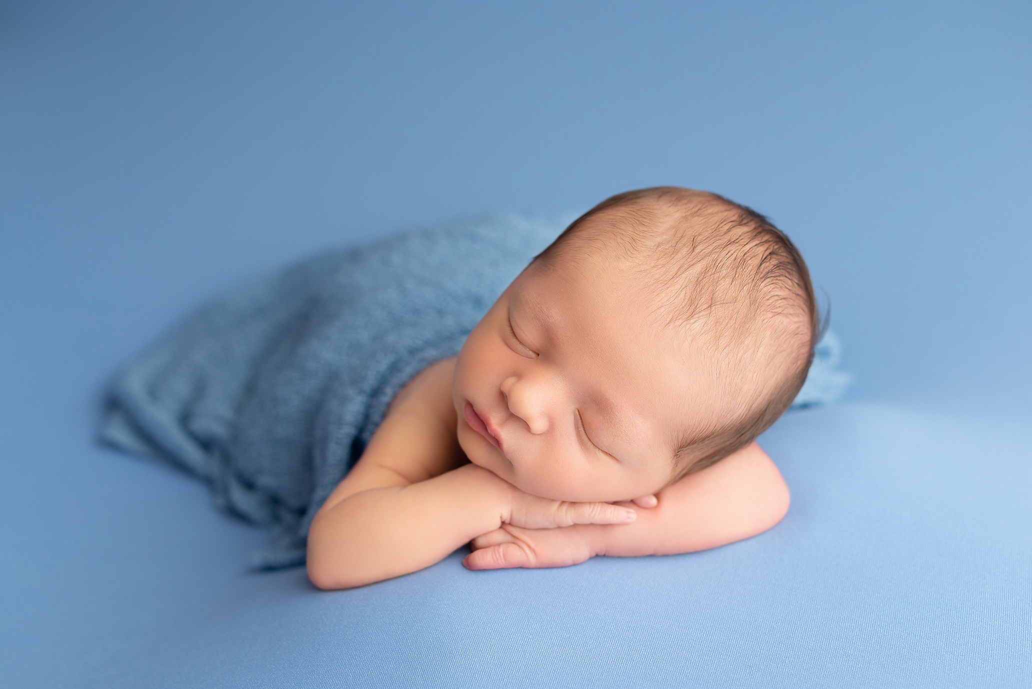 baby boy on blue blanket and wrap