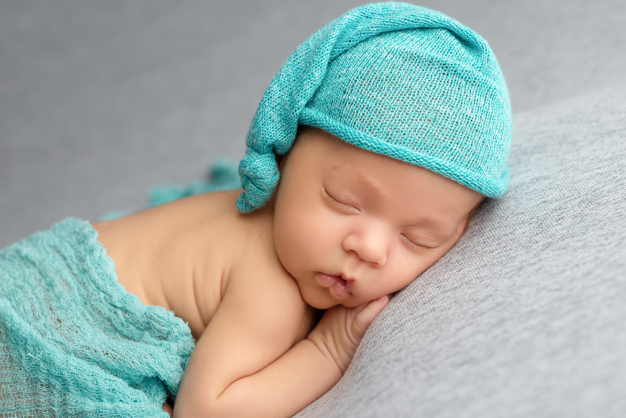baby boy sleeping on grey blanket with teal sleepy hat and wrap in Kingston portrait studio