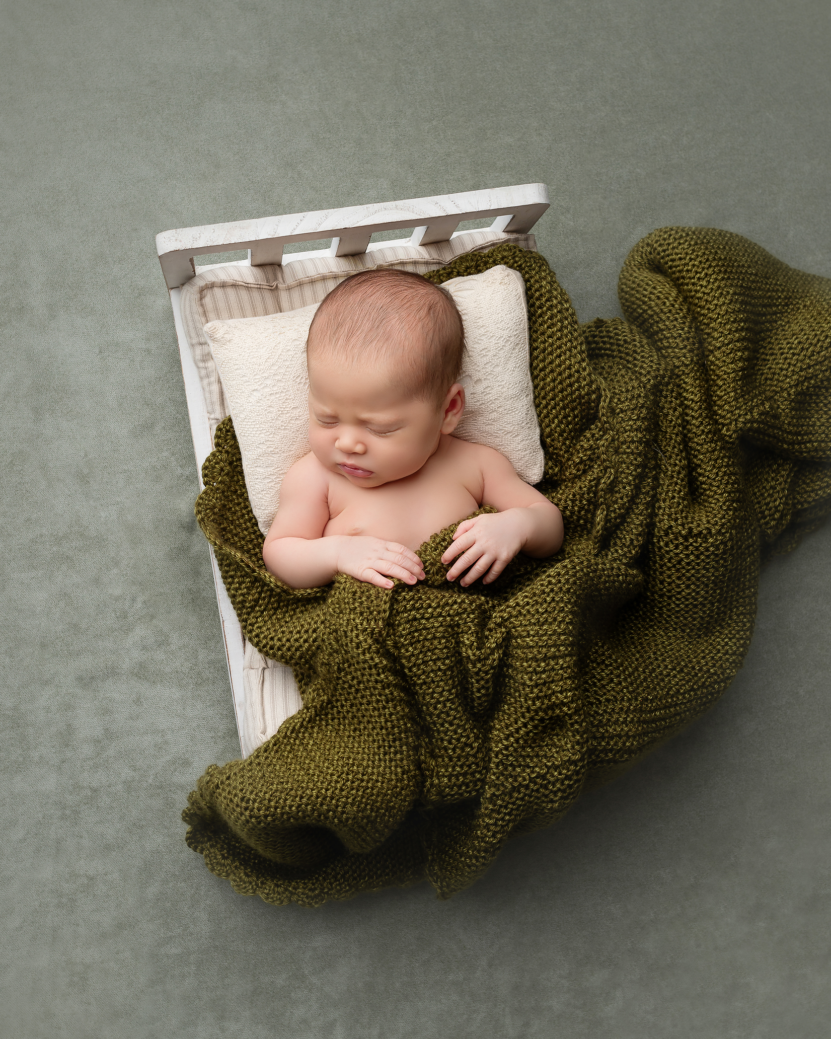 newborn-girl-bed-green-knit-blanket-kingston-family-portraits.png