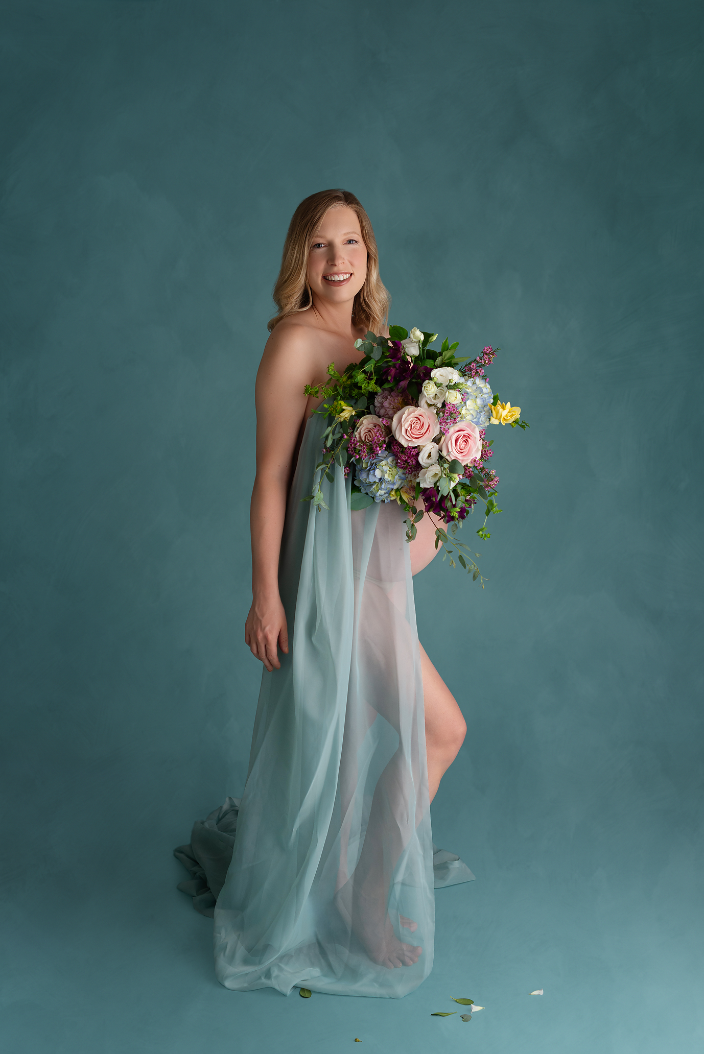 pregnant mother with blue fabric and flowers