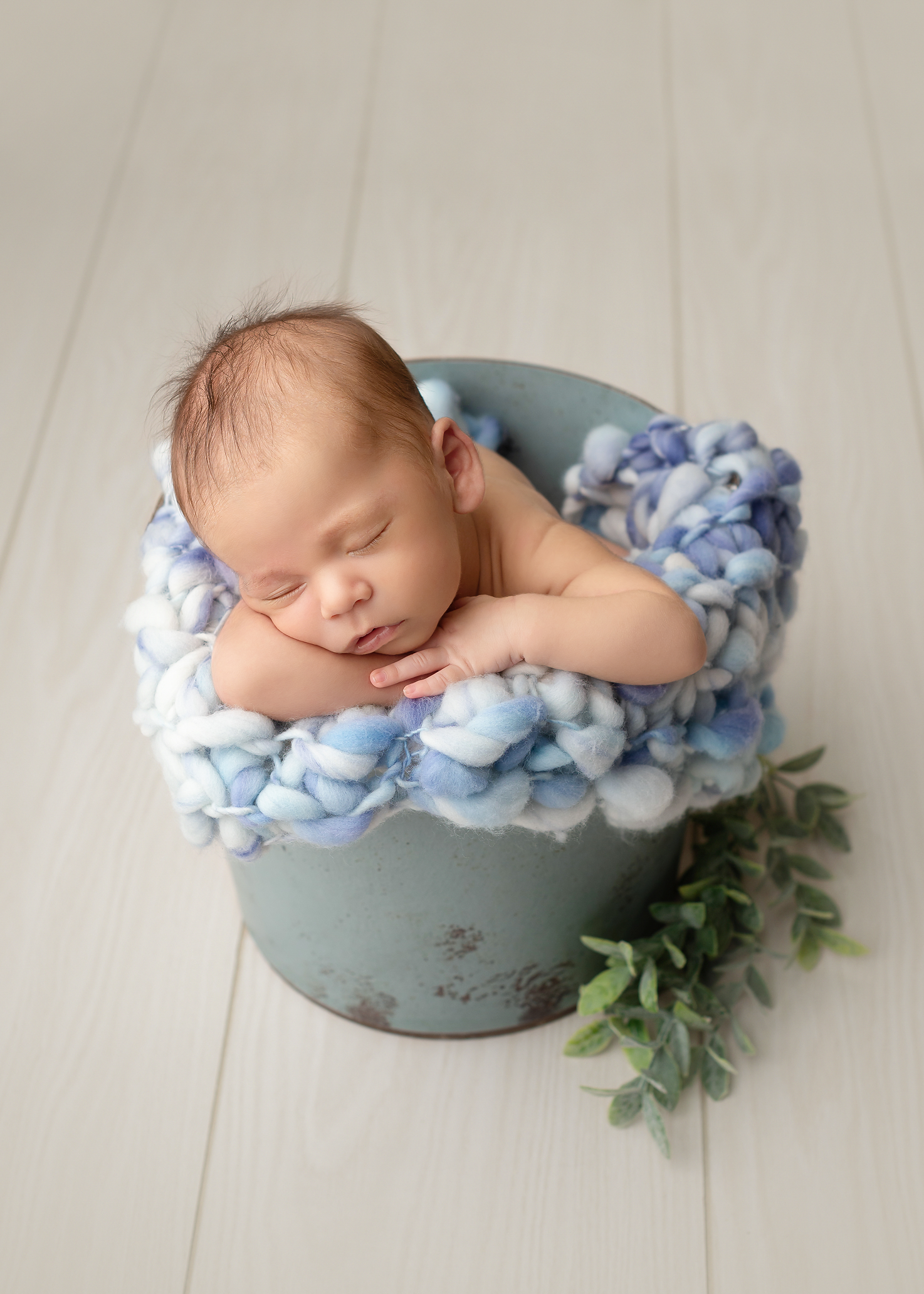 baby boy in blue bucket with blue blanket in Kingston portrait studio