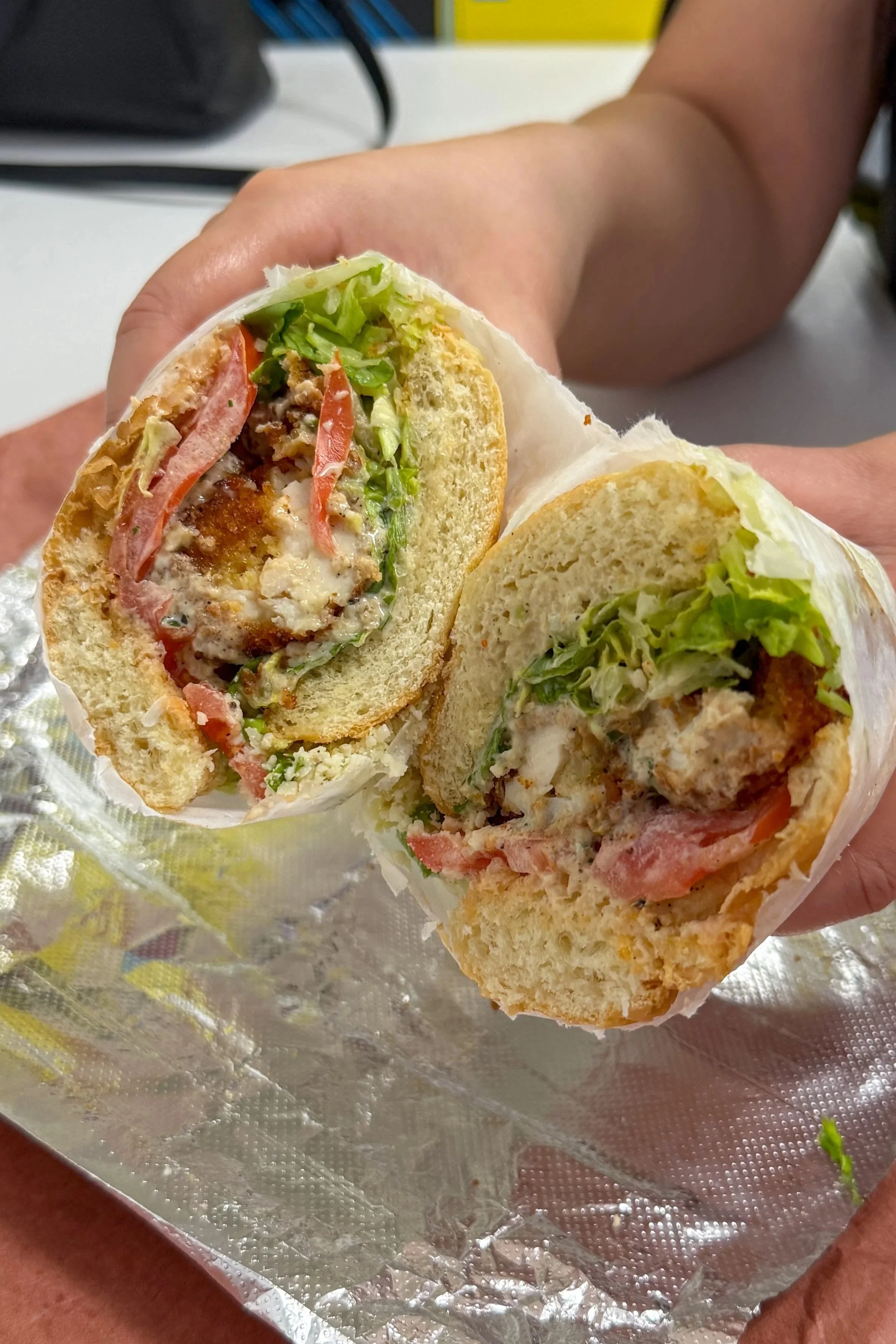 The Chicken Caesar sandwich at Mochi's Deli in Charlotte, a crispy cutlet with romaine, tomato, and creamy dressing