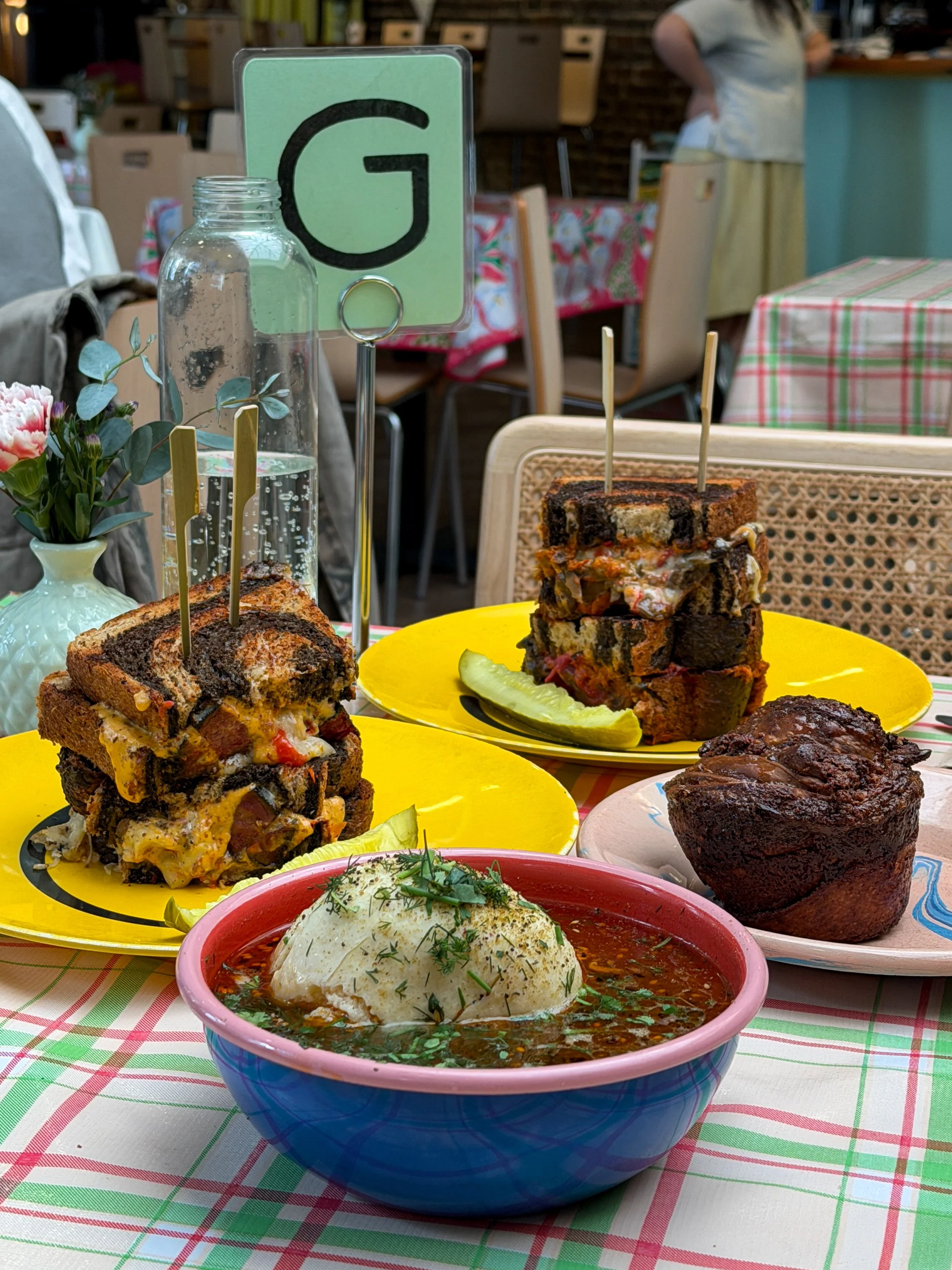 A full table spread at Potchke Deli in Knoxville, including the Pastrami Reuben, Mushroom Melt, chocolate babka, and fussed-up matzoh ball soup