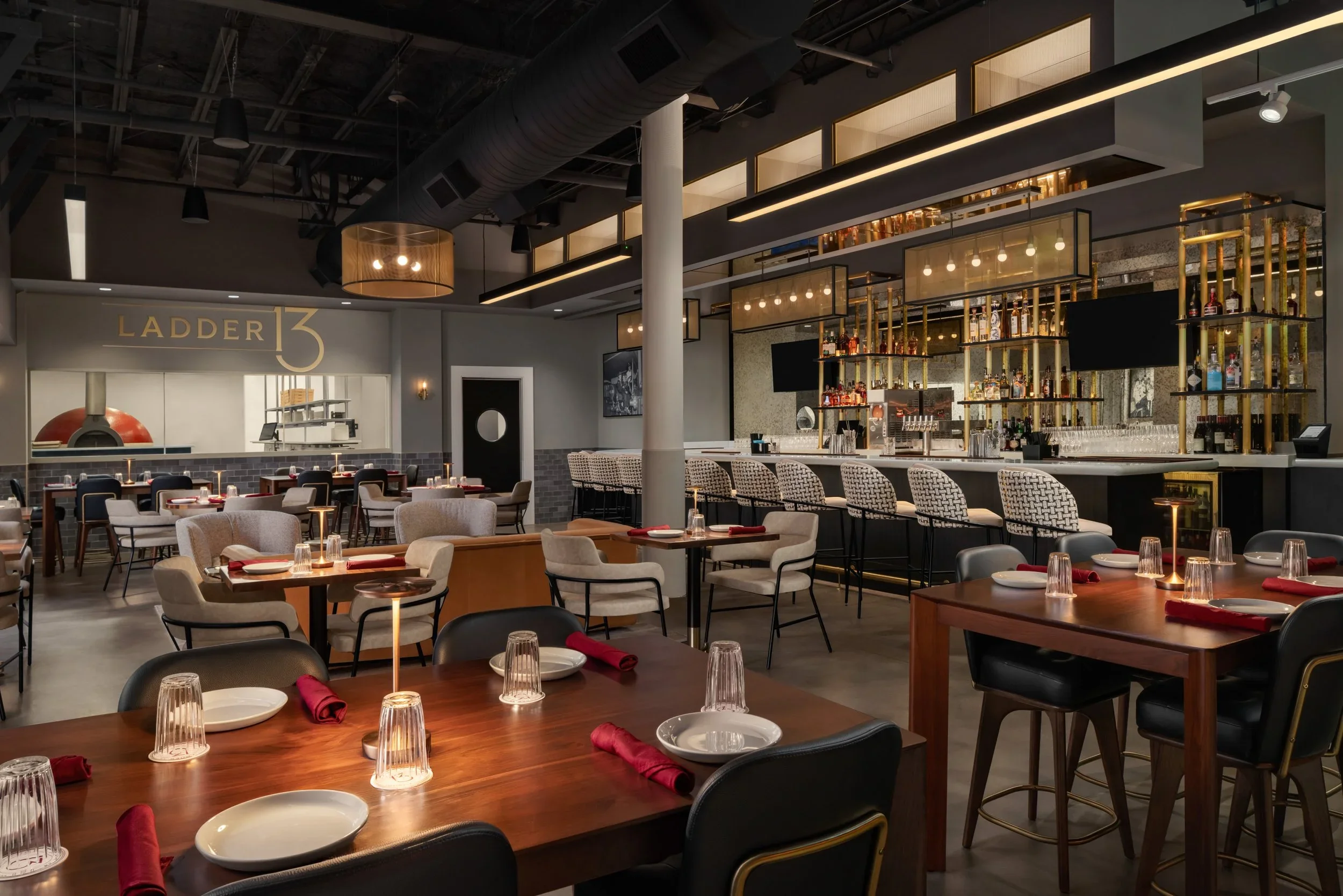 Interior of Ladder 13 restaurant with wood-fired pizza oven inside The Lantern Hotel's historic engine bay