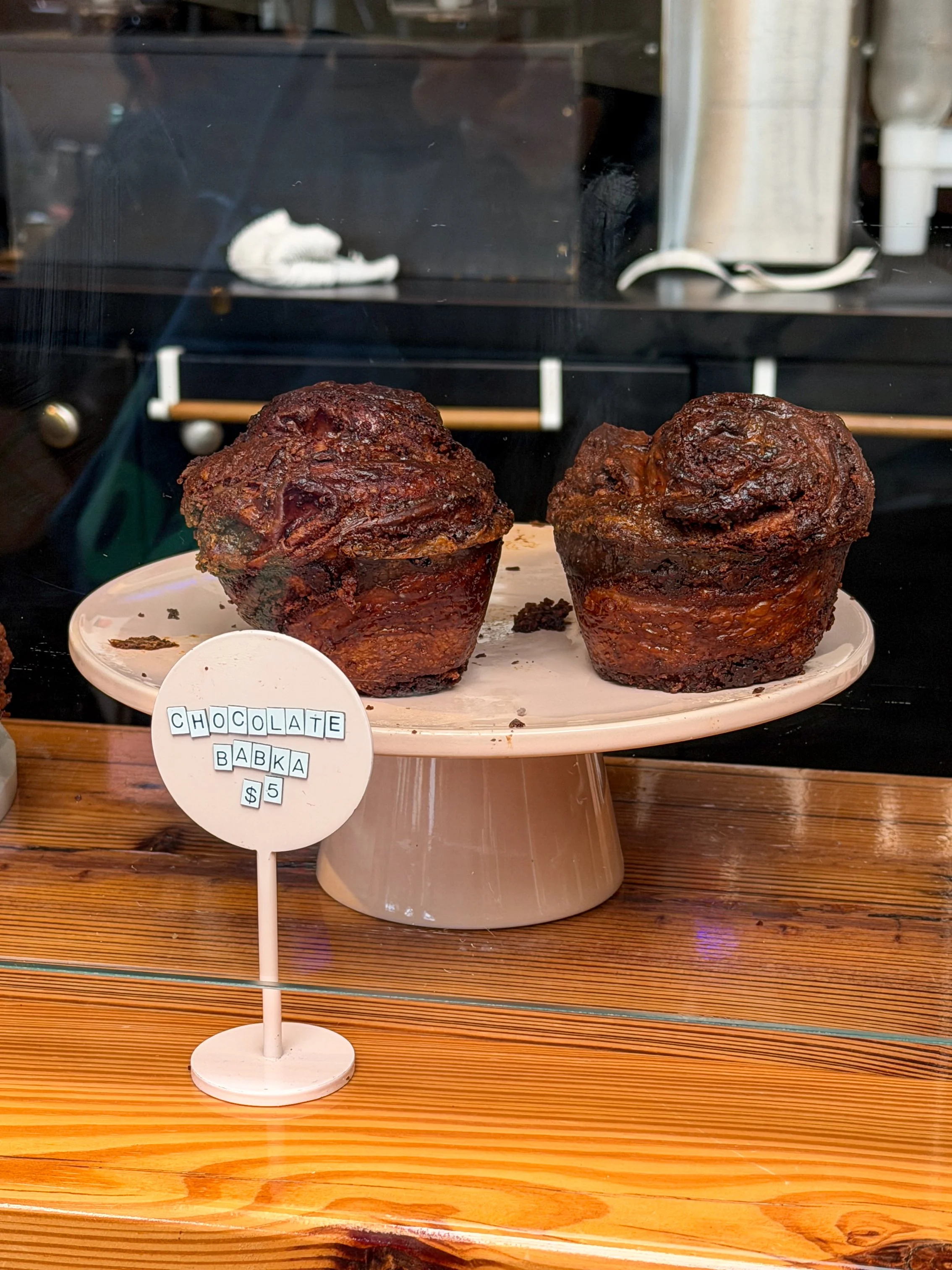Two chocolate babka rolls displayed in the bakery case at Potchke Deli in Knoxville, priced at five dollars each