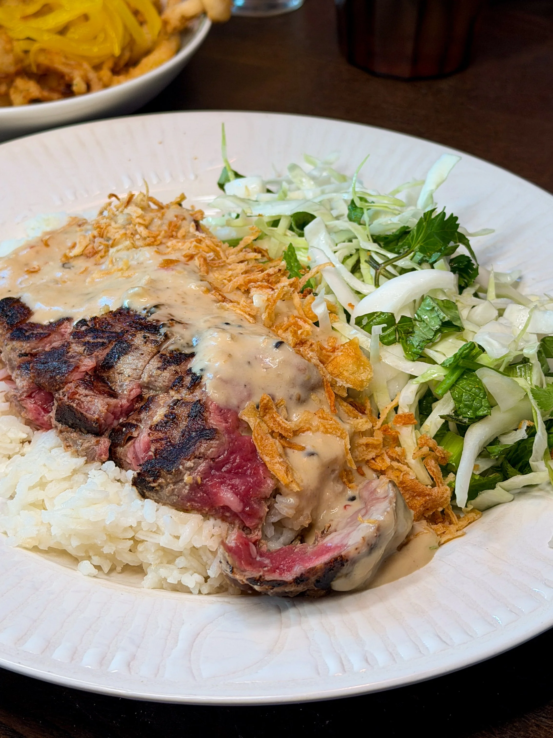Steak au Szechuan with pepper gravy, herby slaw, and coconut rice at Little Secret