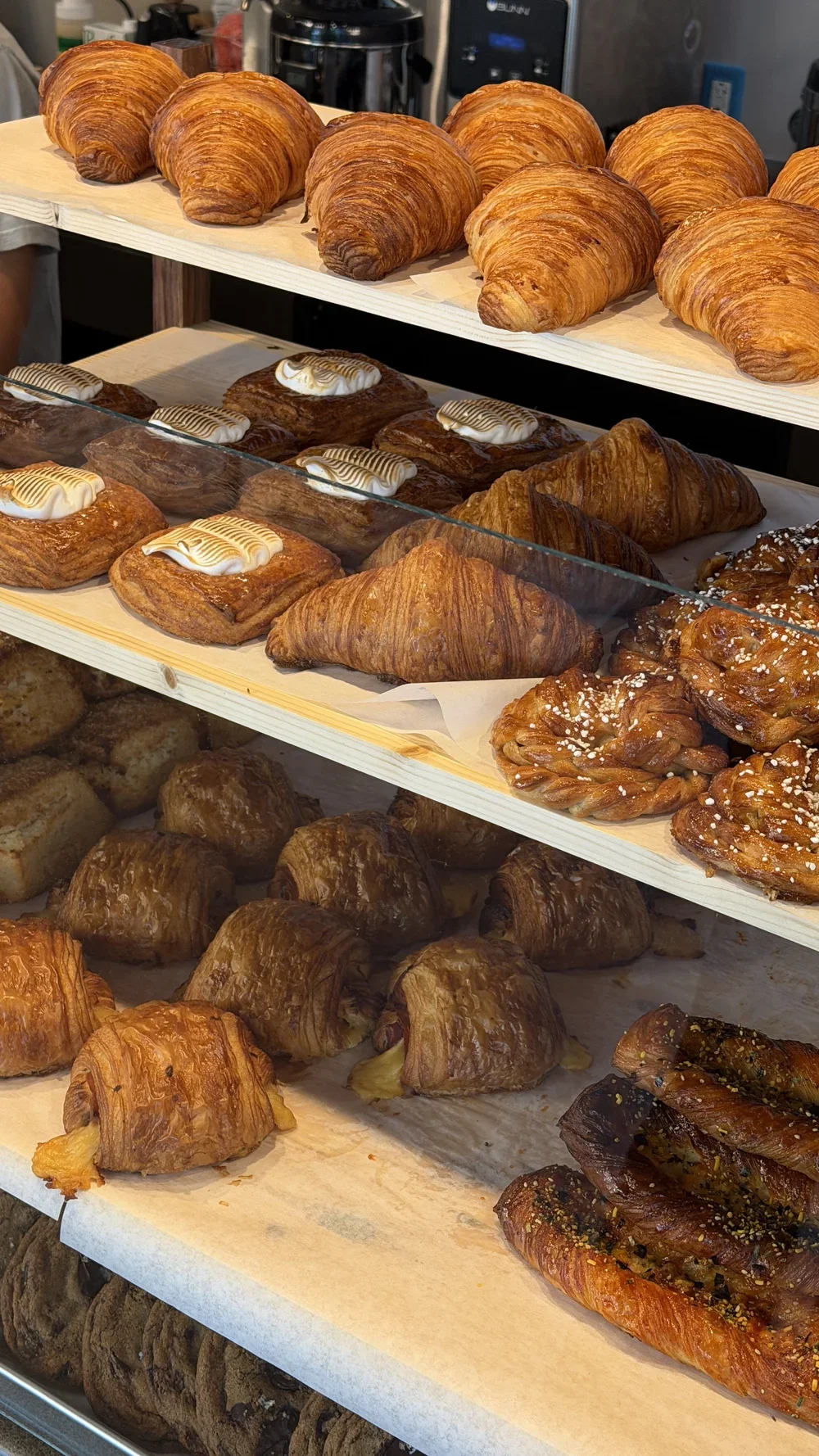 Bakery case filled with croissants, cardamom buns, and laminated pastries at Nine of Cups in Greenville